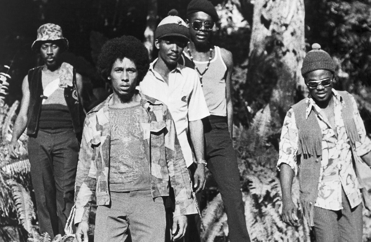 Band photo of The Wailers with Bob Marley in the front and trees behind the group