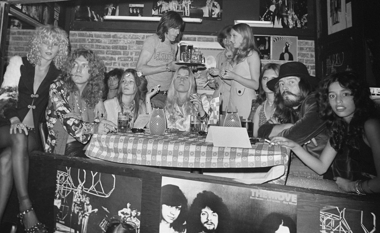 Members of Led Zeppelin surrounded by groupies in a Los Angeles club, 1972