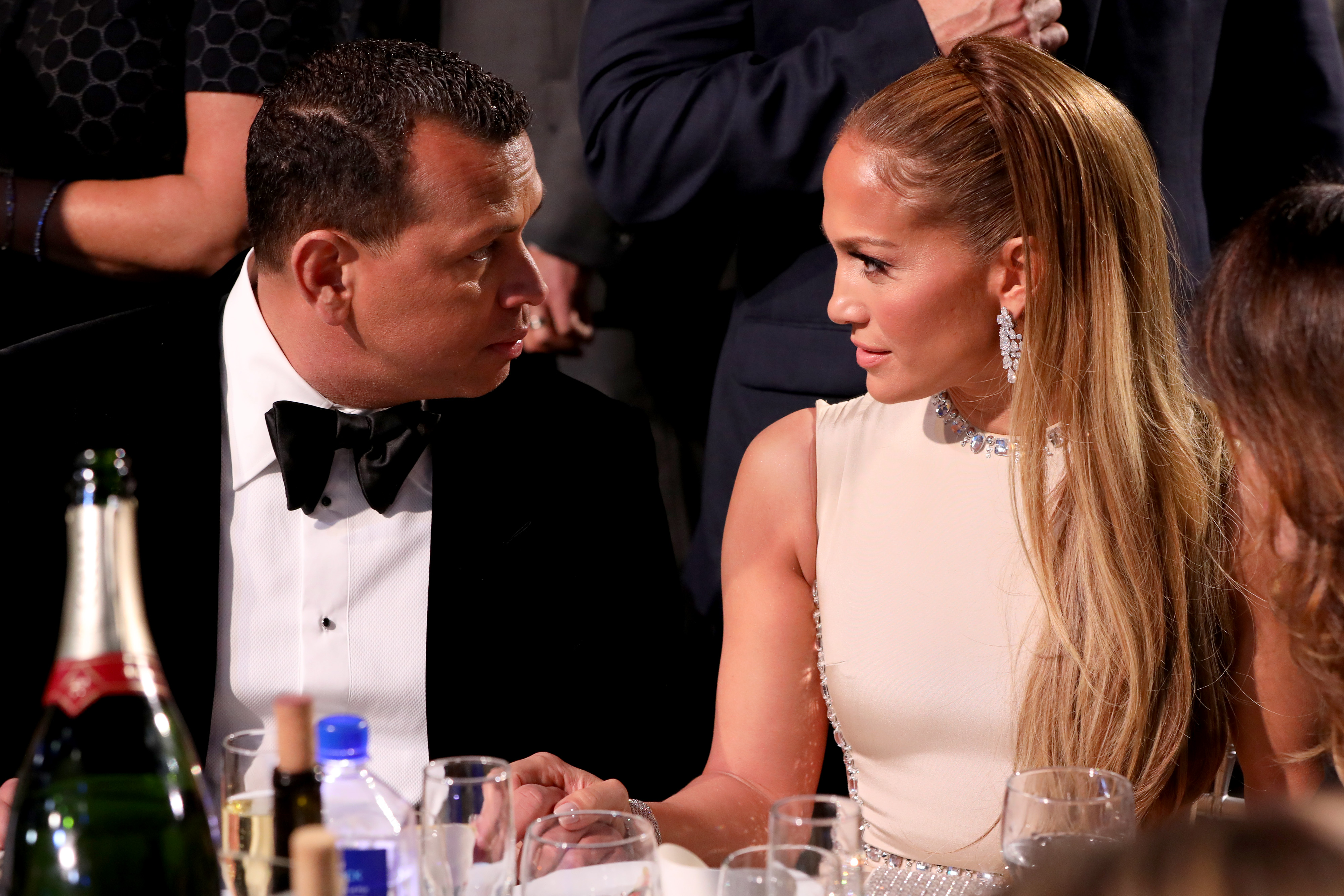 Alex Rodriguez and Jennifer Lopez sitting down at their table during the 25th Annual Critics' Choice Awards