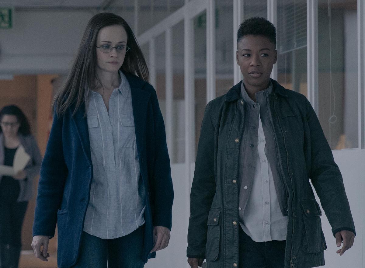 Alexis Bledel as Emily and Samira Wiley as Moira walking in a naturally lit hallway in 'The Handmaid's Tale' Season 4