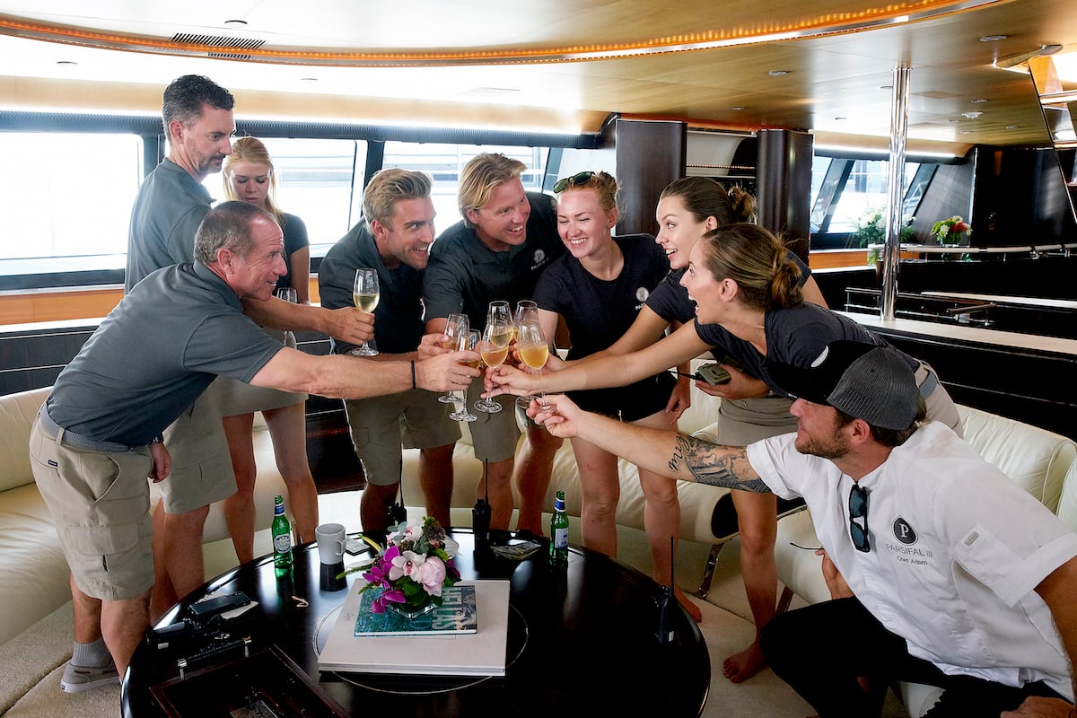 Below Deck Sailing Yacht Season 1 crew toast to a successful charter. Captain Glenn Shephard, Byron Hissey, Madison Stalker, Parker McCown, Paget Berry, Ciara Duggan, Georgia Grobler, Jenna MacGillivray, Adam Glick