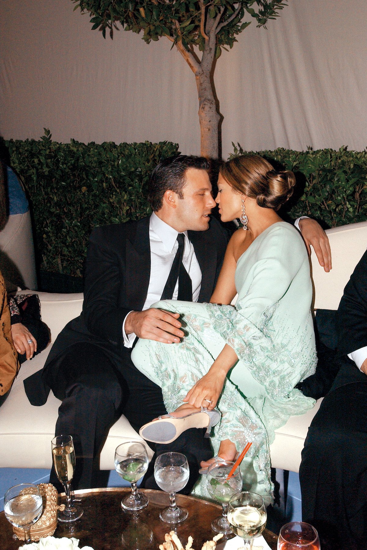 Ben Affleck sits with his arm around Jennifer Lopez