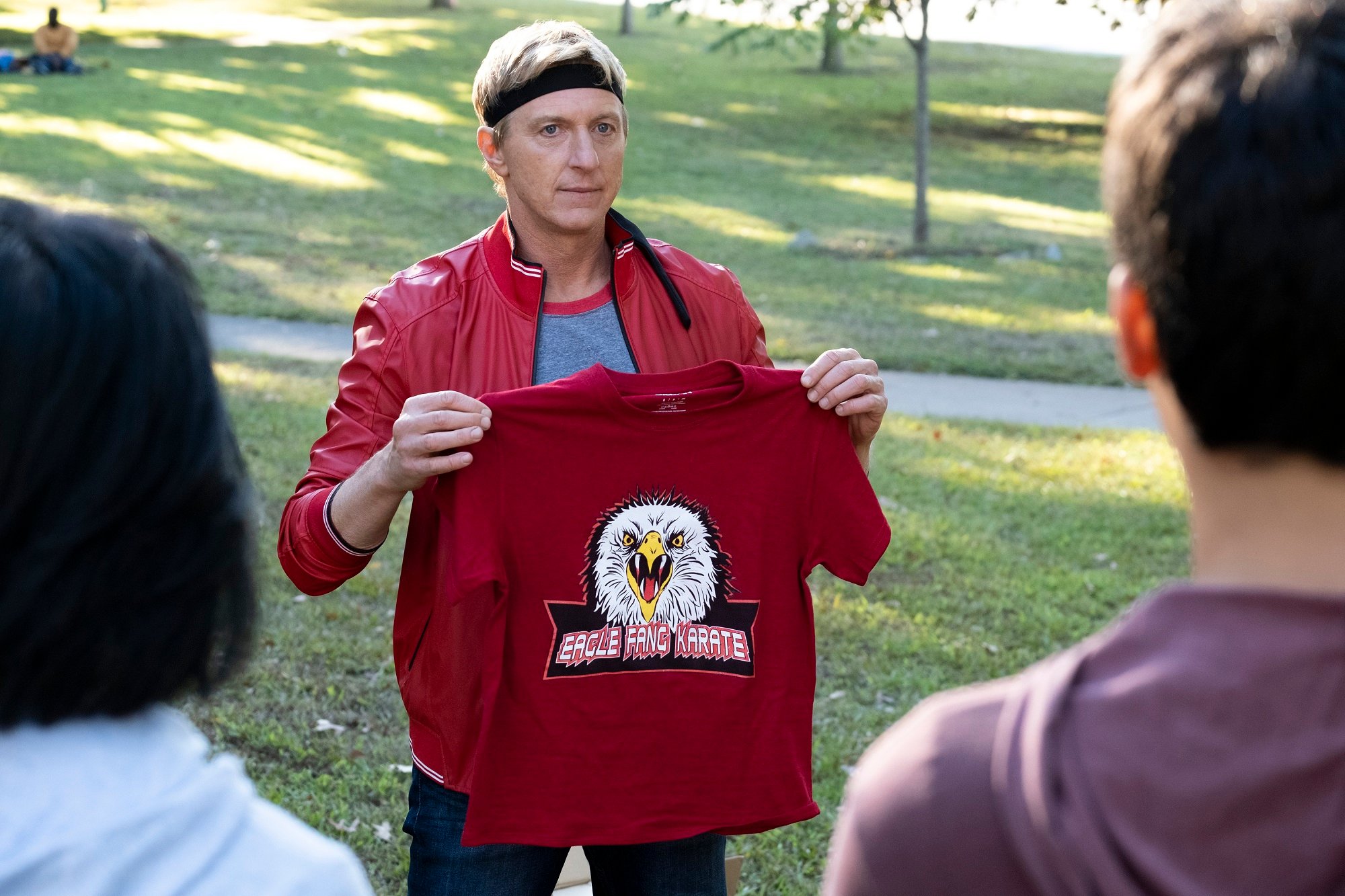 Cobra Kai Season 3: William Zabka holds up an Eagle Fang shirt