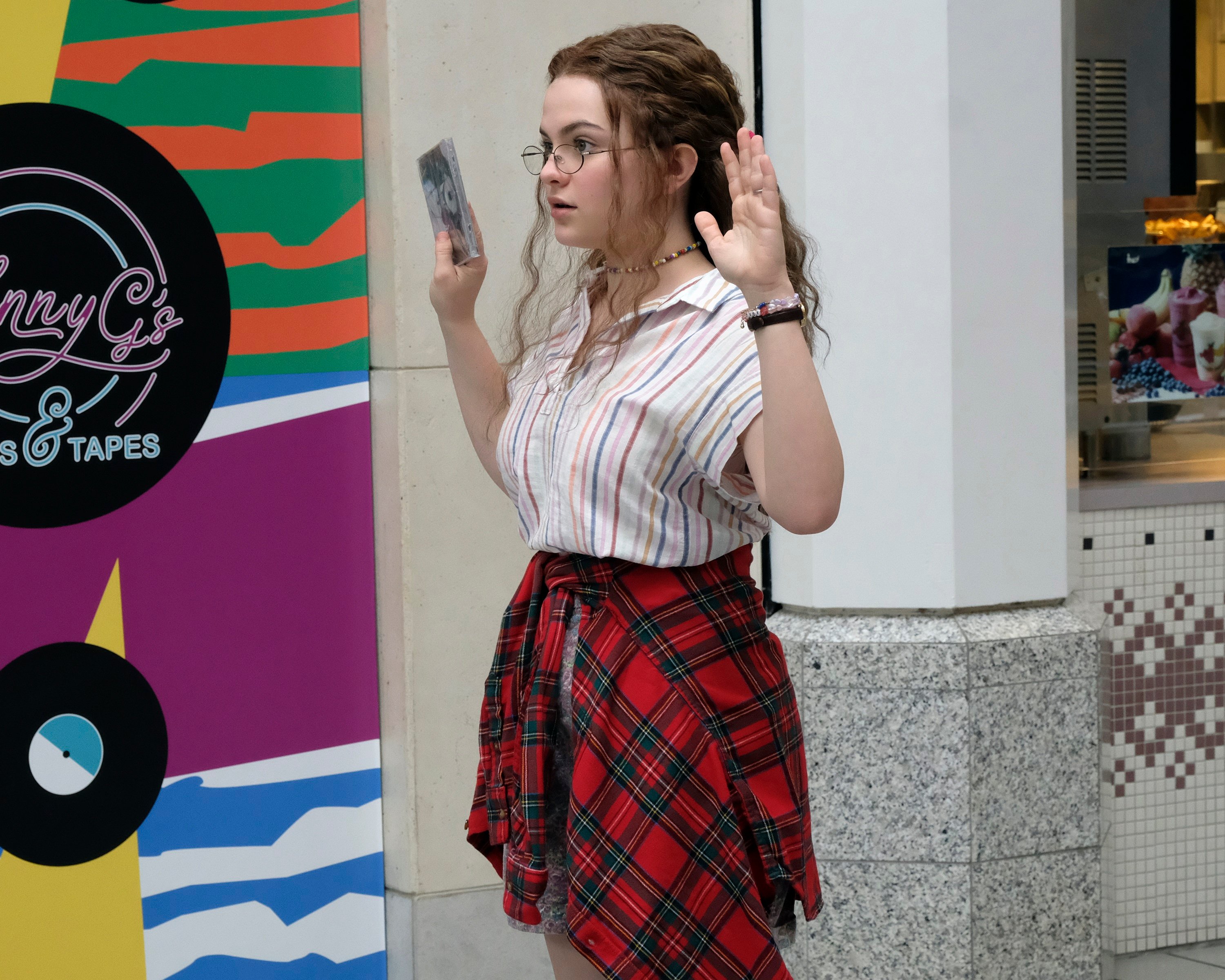 Cruel Summer Episode 6 Chiara Aurelia as Jeanette Turner with her arms up in the air at the mall