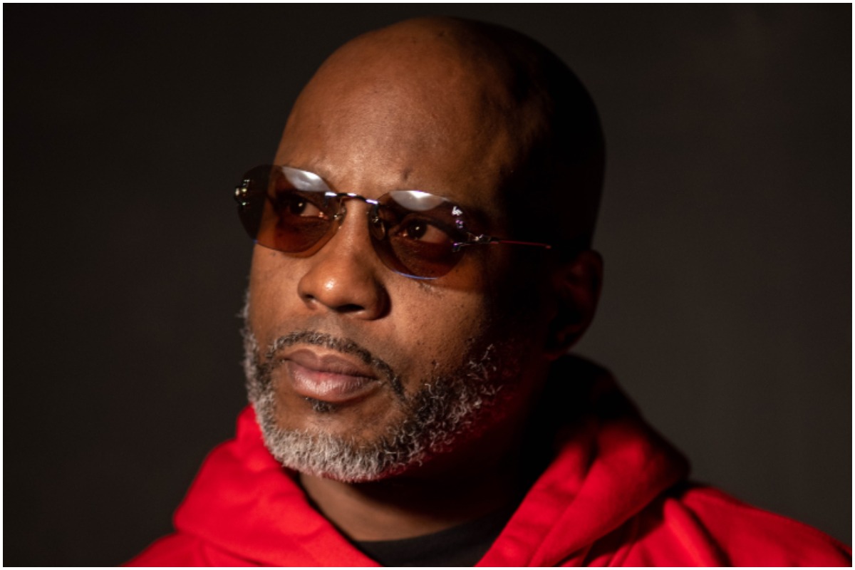 DMX looking away from the camera with black sunglasses and a red hoodie