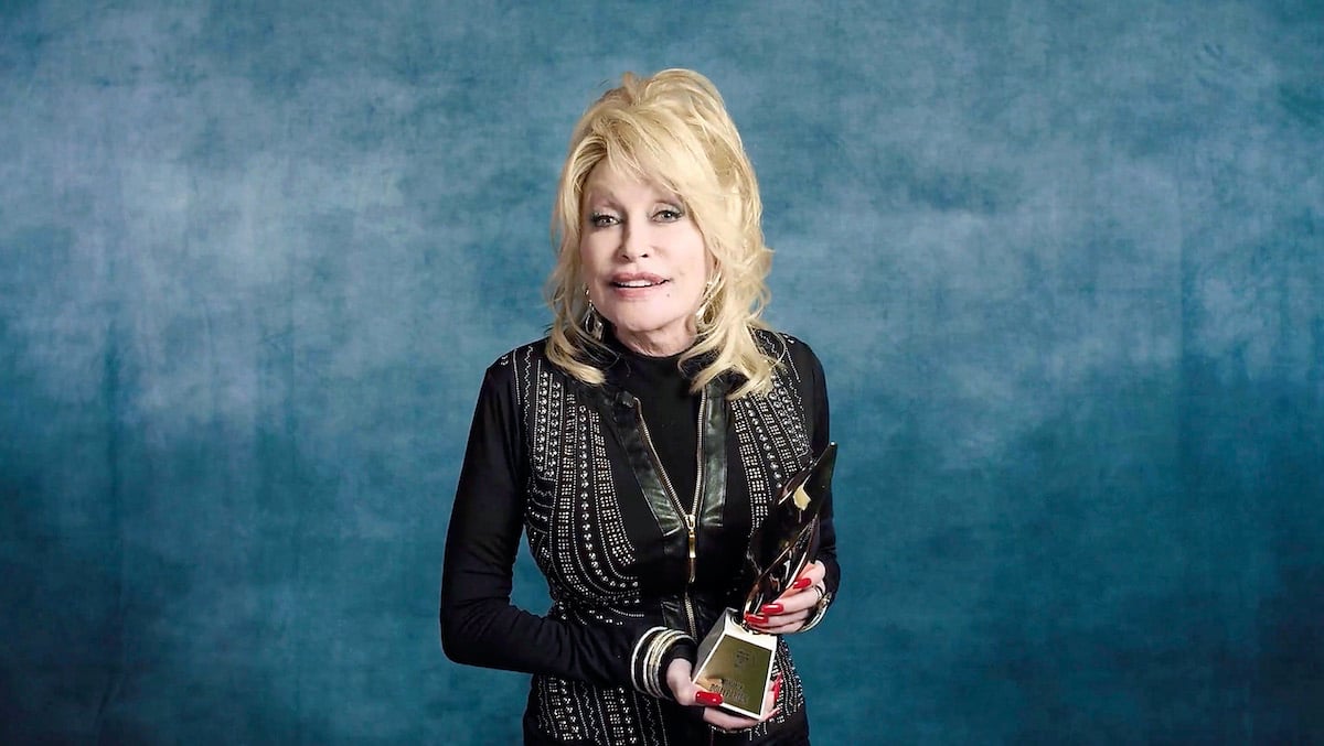 Dolly Parton smiles in a black outfit and a necklace at the We Are Family Foundation