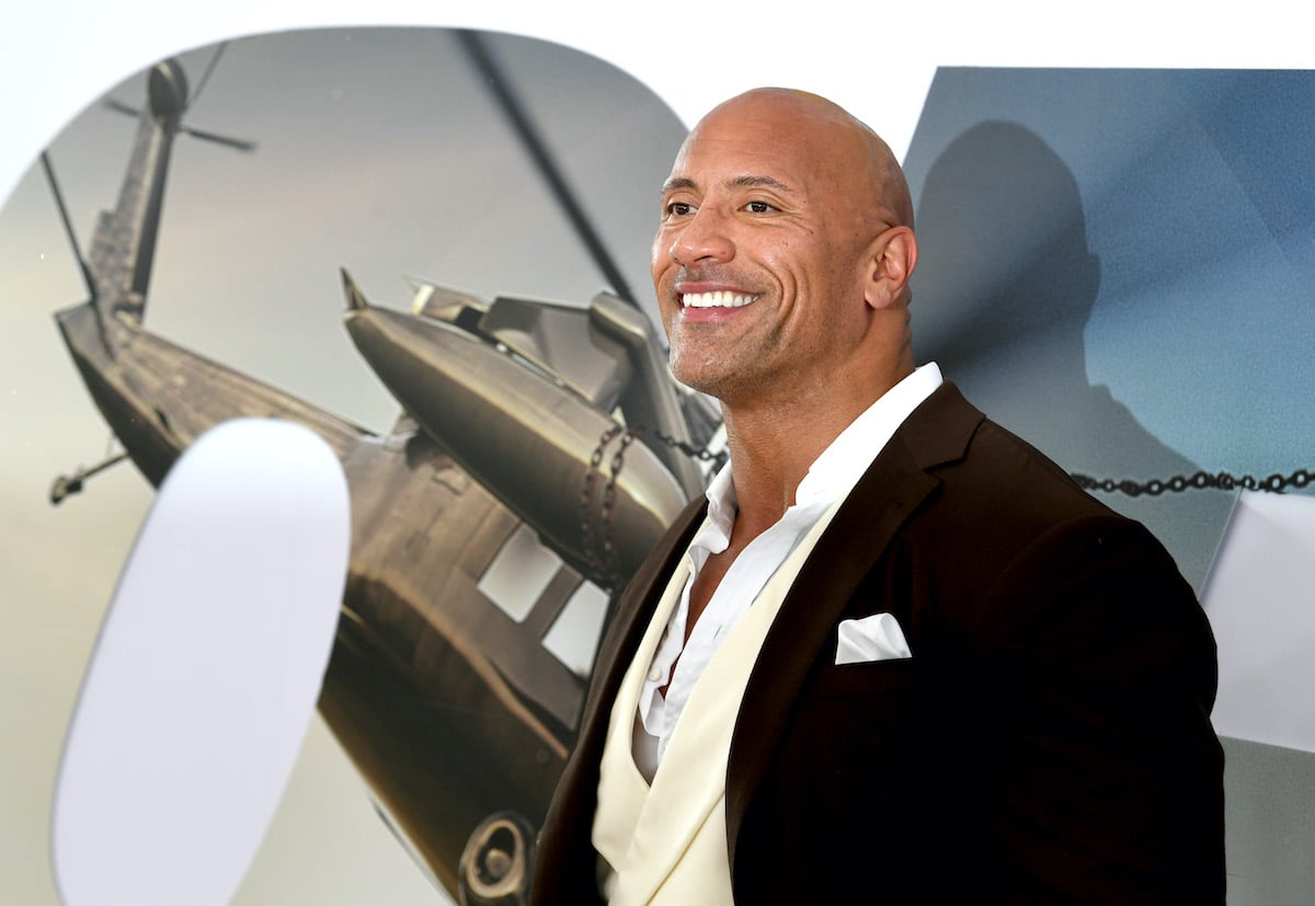Dwayne Johnson poses in front of an image promoting 'Fast & Furious Presents: Hobbs & Shaw' at the movie's premiere