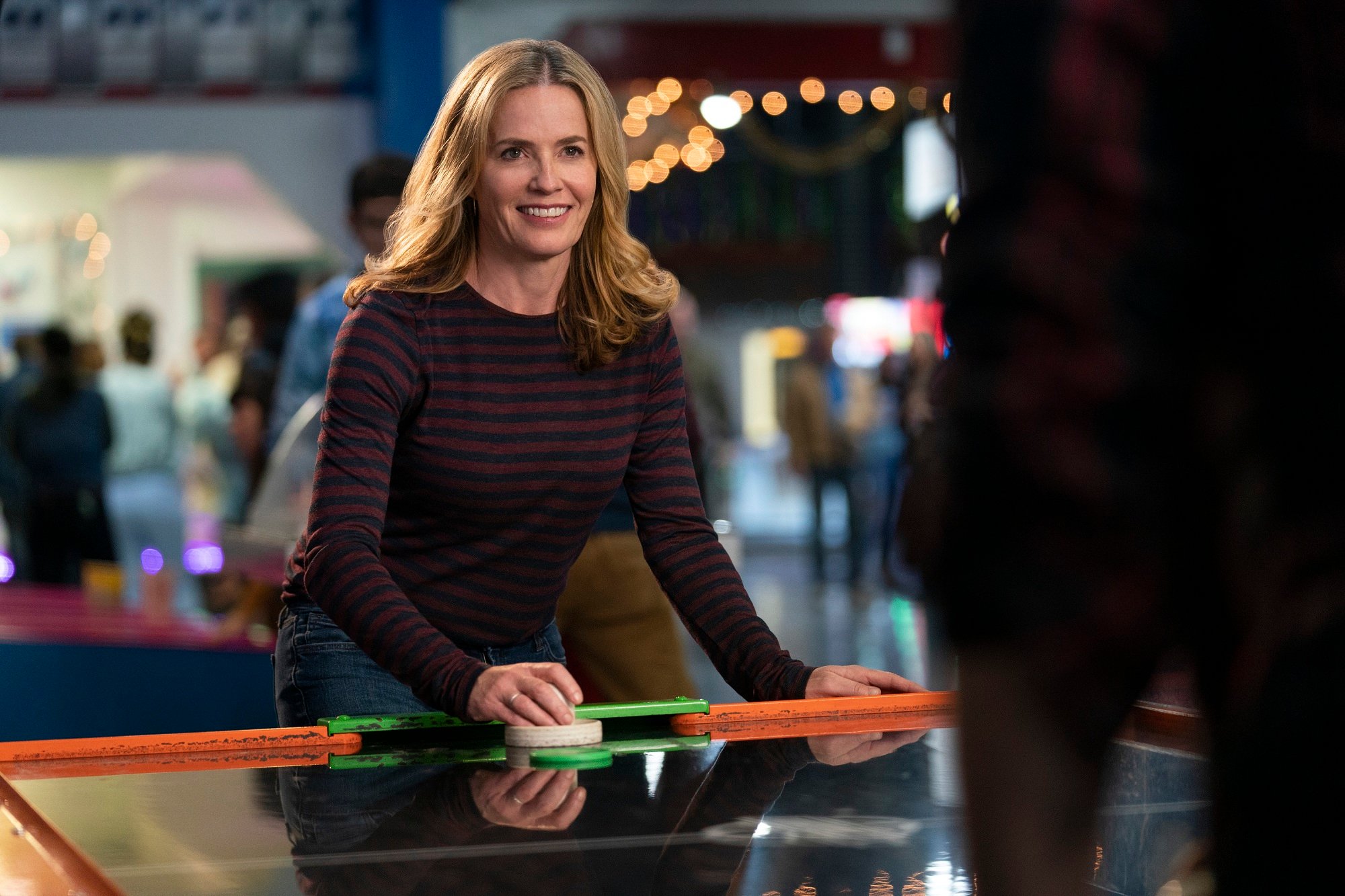 Elisabeth Shue plays air hockey on Cobra Kai