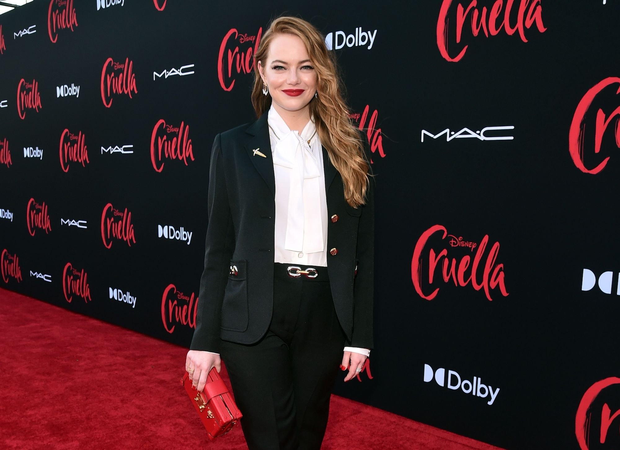 Emma Stone standing on the red carpet at the premiere for 'Cruella'