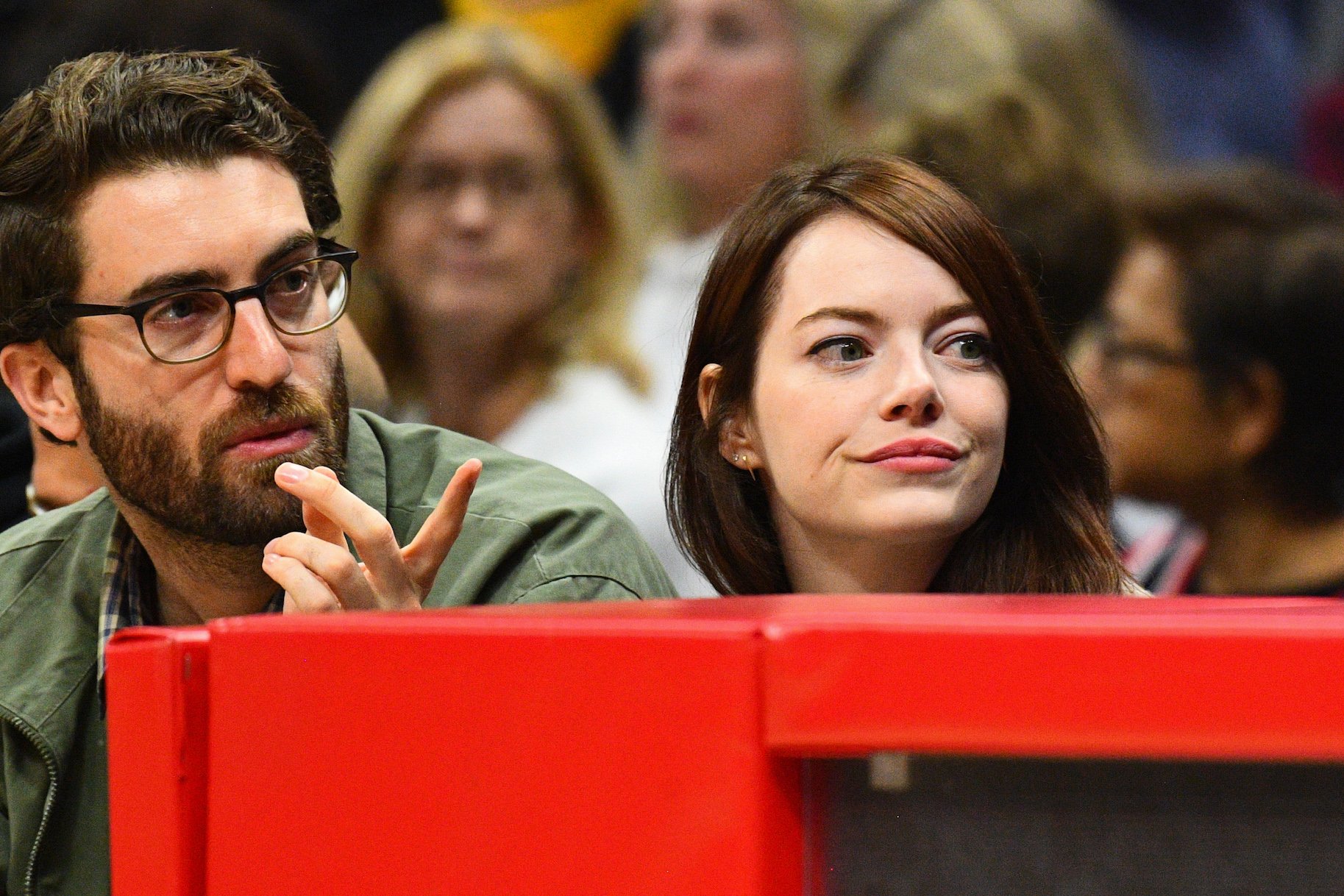 Emma Stone and her husband, Dave McCary, sitting at a basketball game