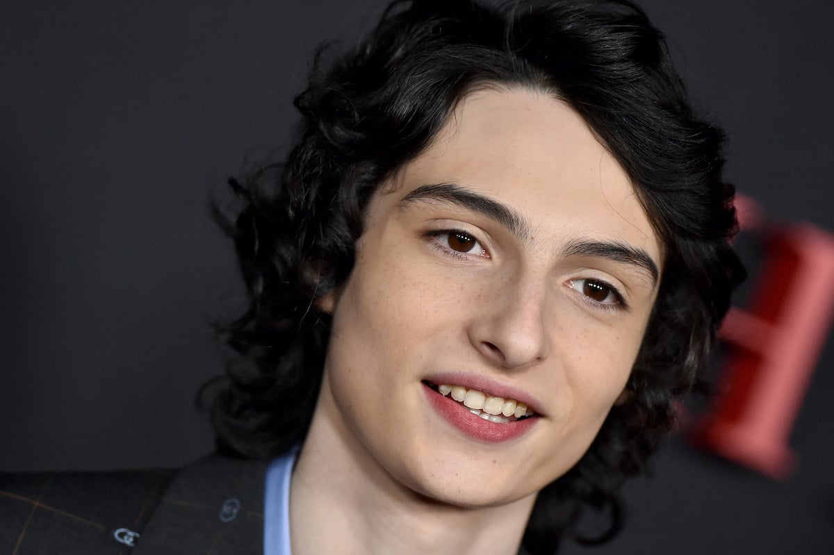 Finn Wolfhard in a blue shirt and black jacket at 'The Turning' premiere