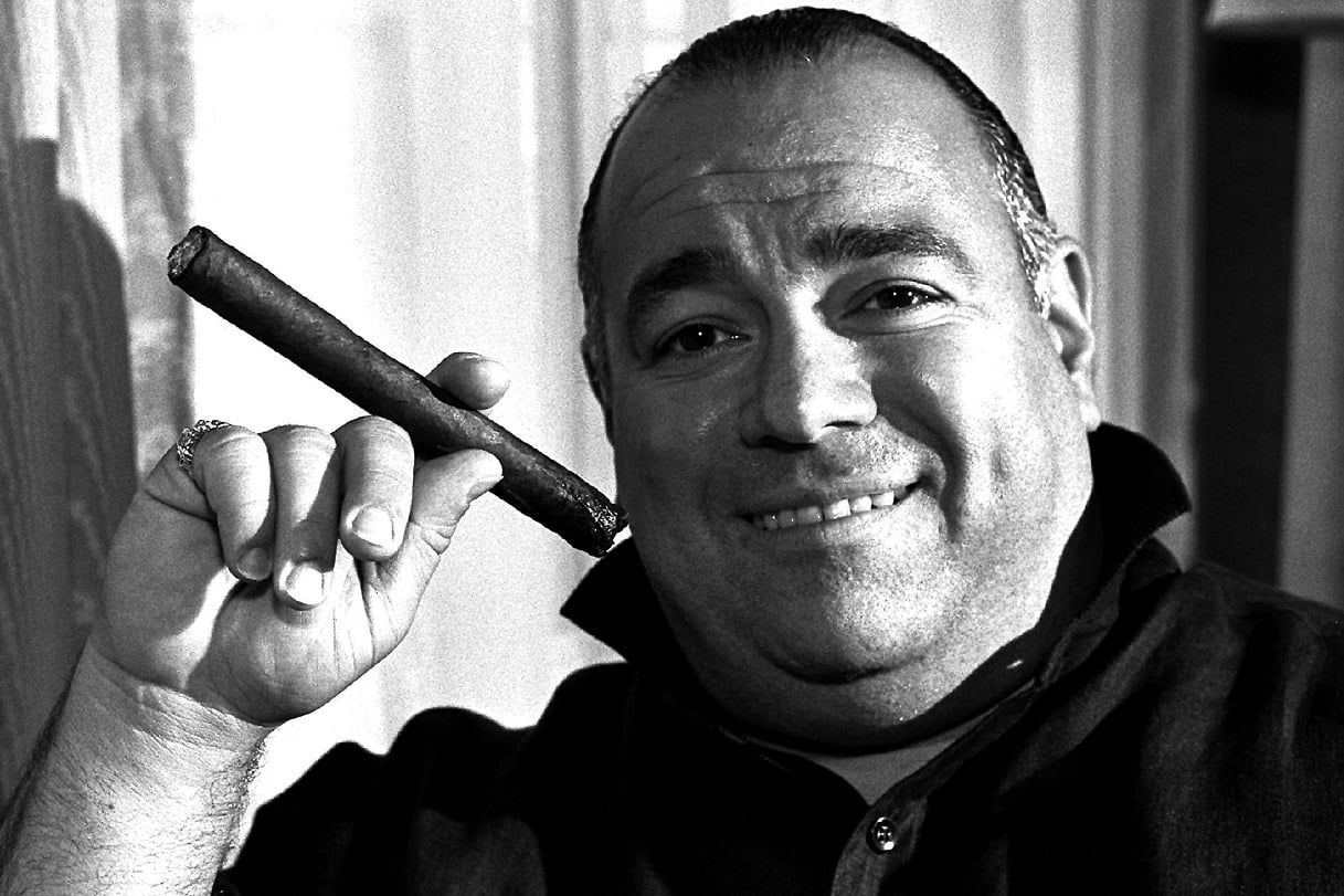 Frank DiLeo smiles and holds a cigar while posing for a photo