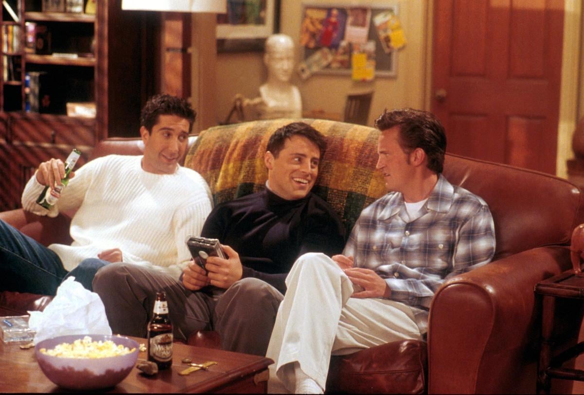 David Schwimmer, Matt LeBlanc, and Matthew Perry sitting on a couch in character on 'Friends'