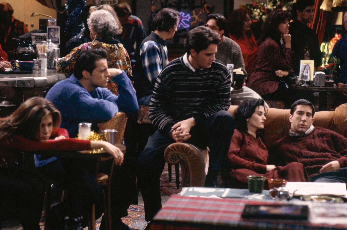 Jennifer Aniston as Rachel Green, Matt Le Blanc as Joey Tribbiani, Matthew Perry as Chandler Bing, Courteney Cox as Monica Geller, David Schwimmer as Ross Geller sit in Central Perk looking sad in 'Friends'