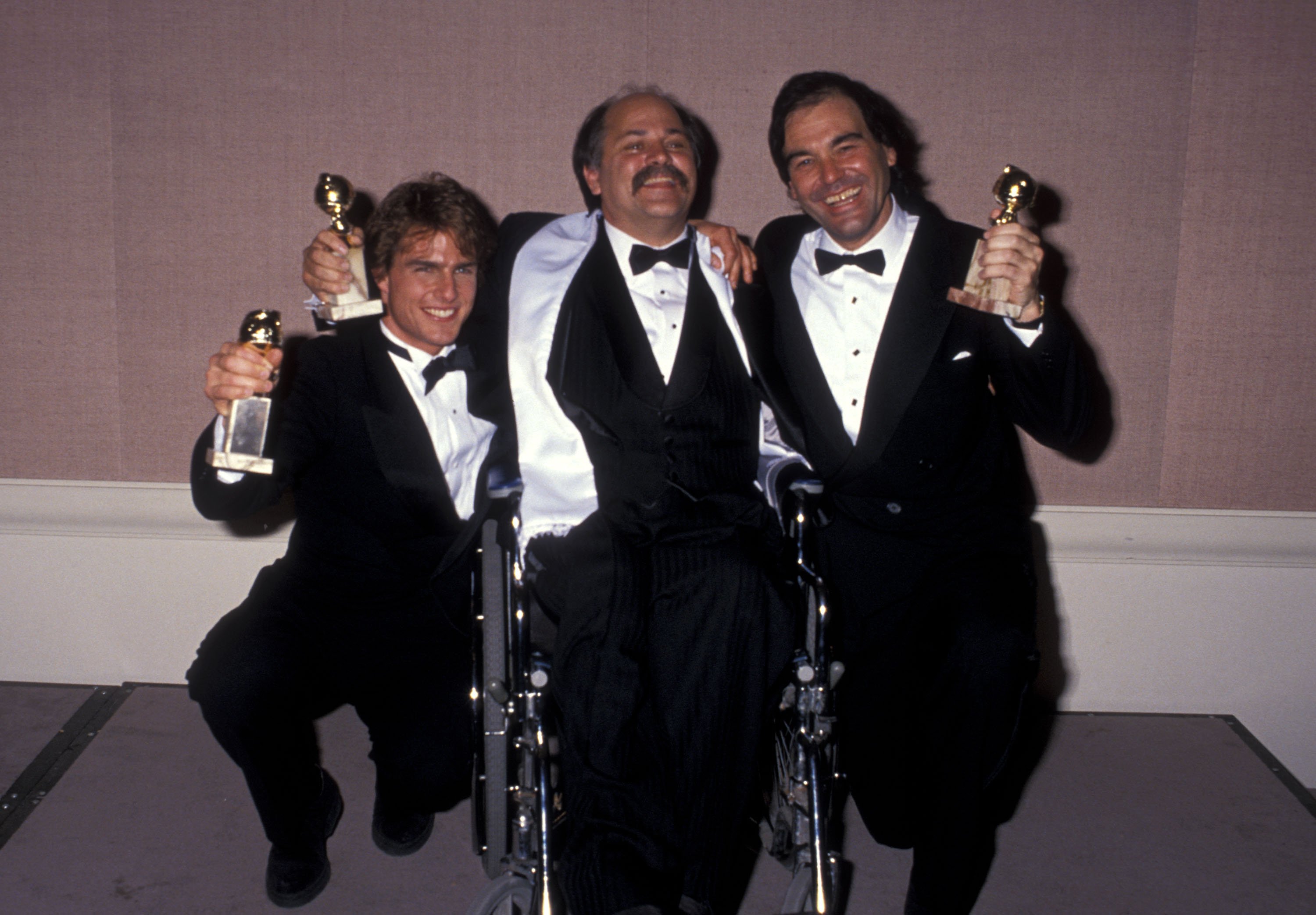 Golden Globe winners Tom Cruise, Ron Kovic and Oliver Stone hold their awards