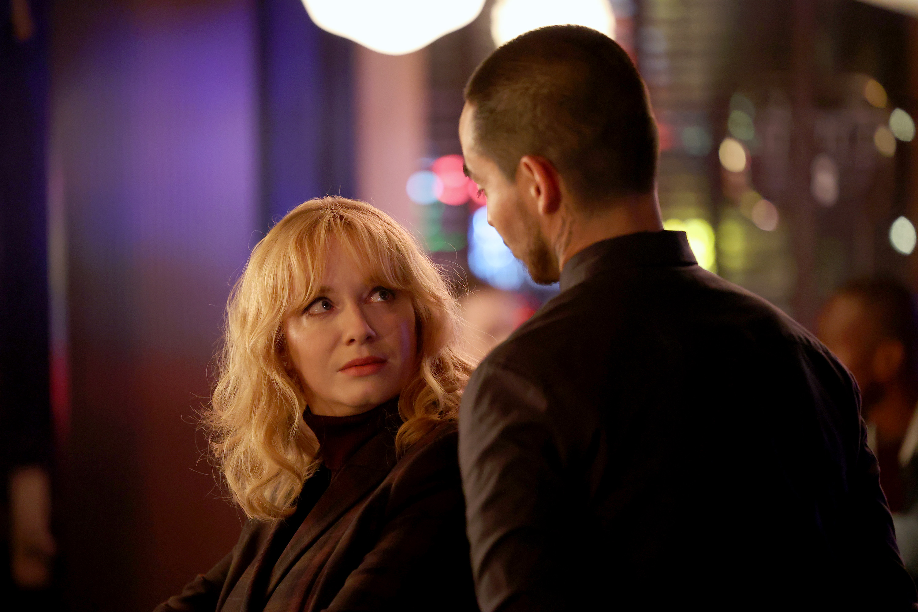 'Good Girls' stars Christina Hendricks and Manny Montana staring intensely at each other as Beth and Rio.
