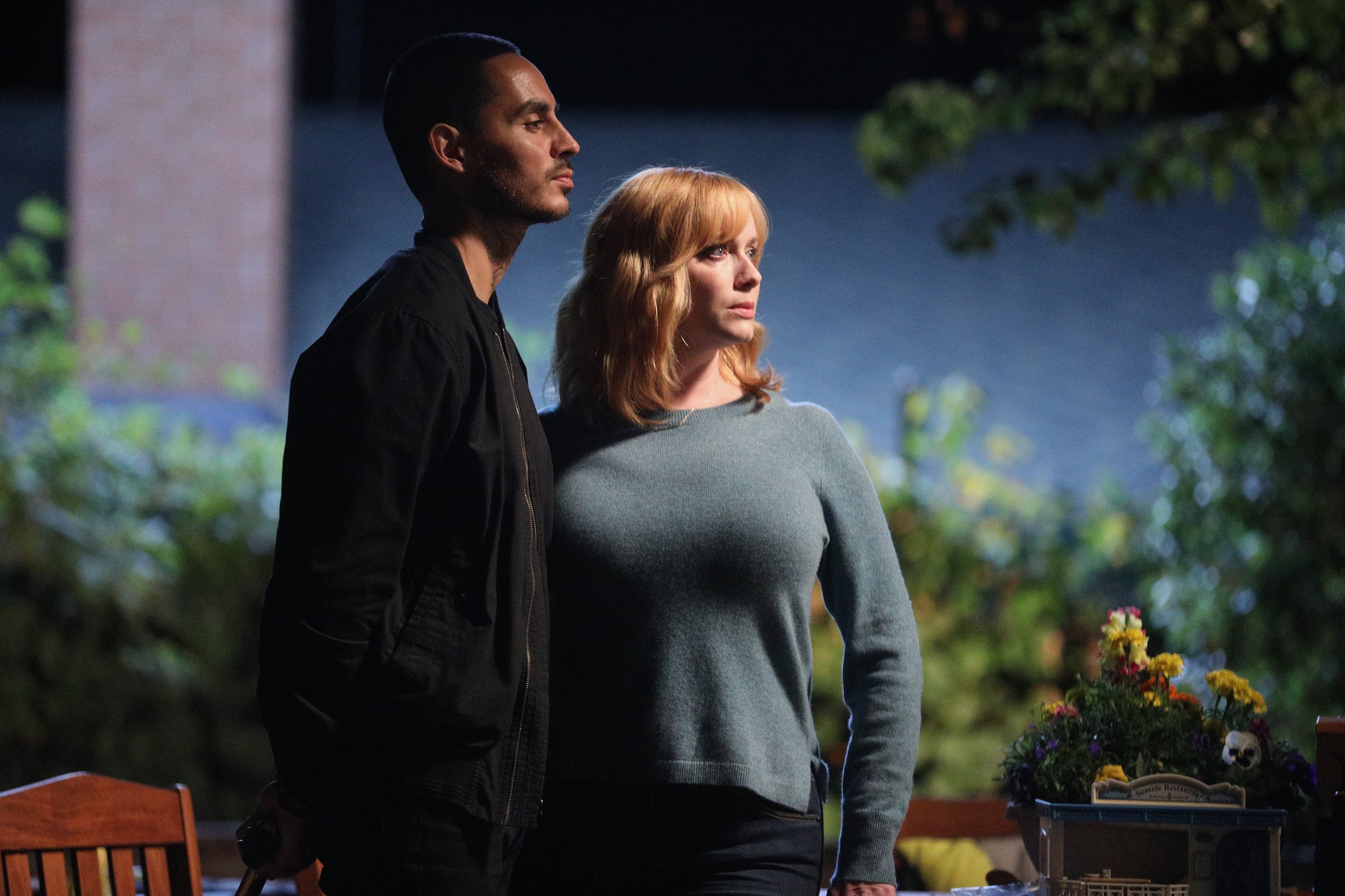 'Good Girls' actors Christina Hendricks and Manny Montana standing outside as Beth and Rio.