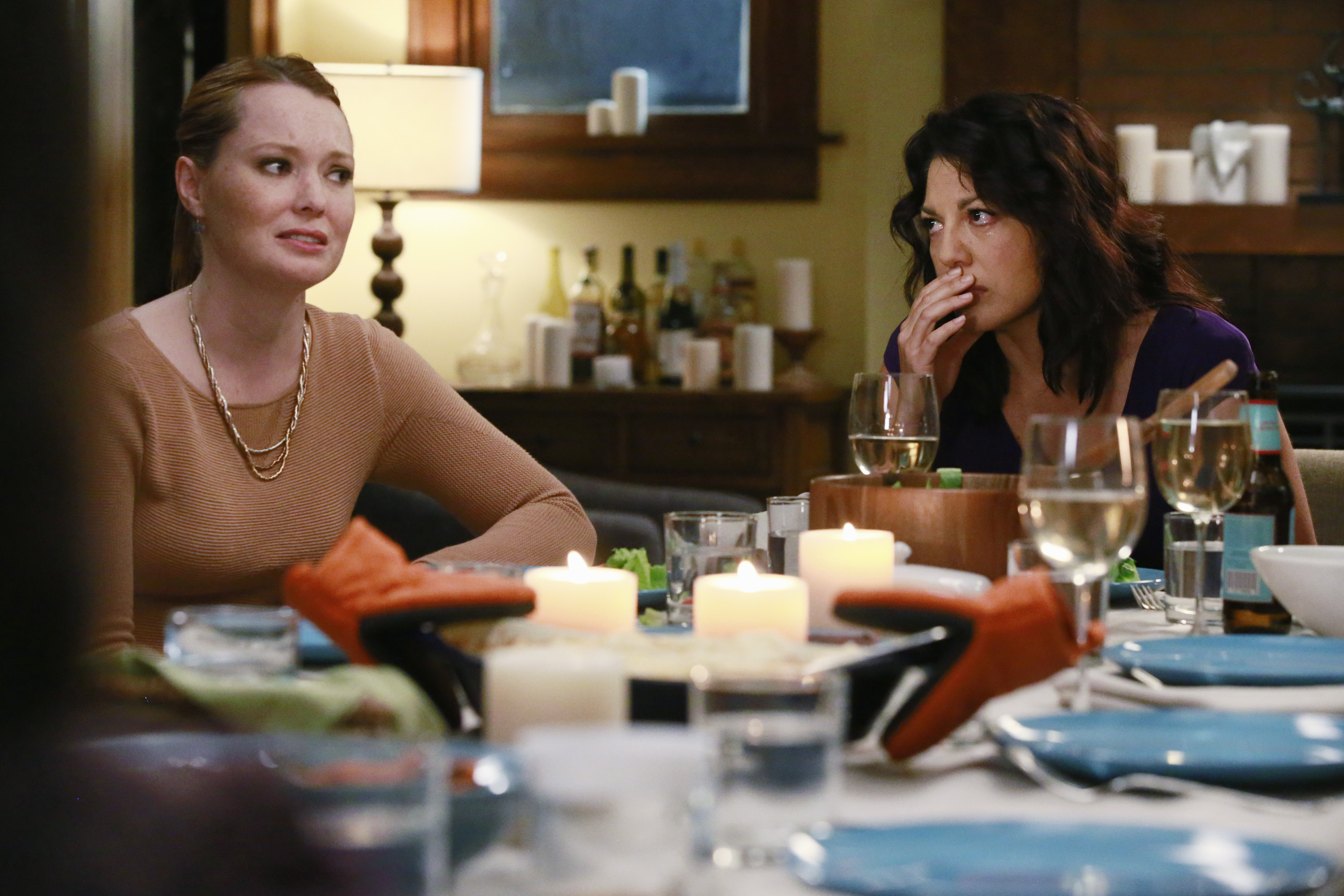 'Grey's Anatomy' stars Samantha Sloyan and Sara Ramirez as Callie Torres crying at a dinner table.