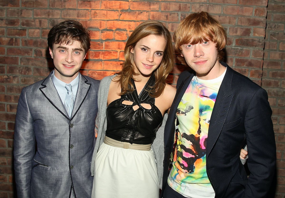 'Harry Potter' actors Daniel Radcliffe, Emma Watson, and Rupert Grint pose together in front of a brick wall
