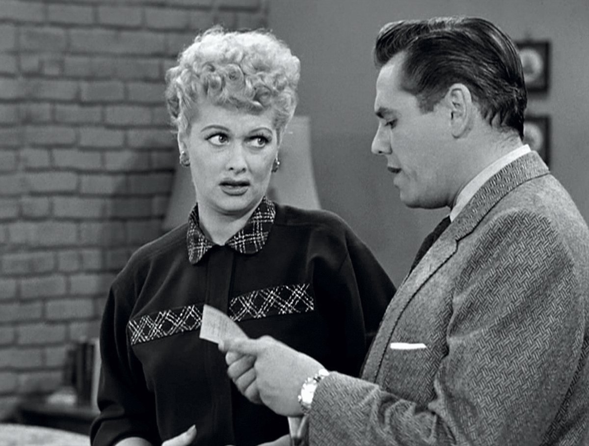 Lucille Ball as Lucy Ricardo listens as Desi Arnaz as Ricky Ricardo pours a cup of coffee in the kitchen in 'I Love Lucy'