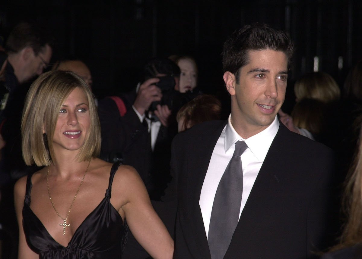 Jennifer Aniston wears a black dress and David Schwimmer wears a black suit during The 27th Annual People's Choice Awards carpet