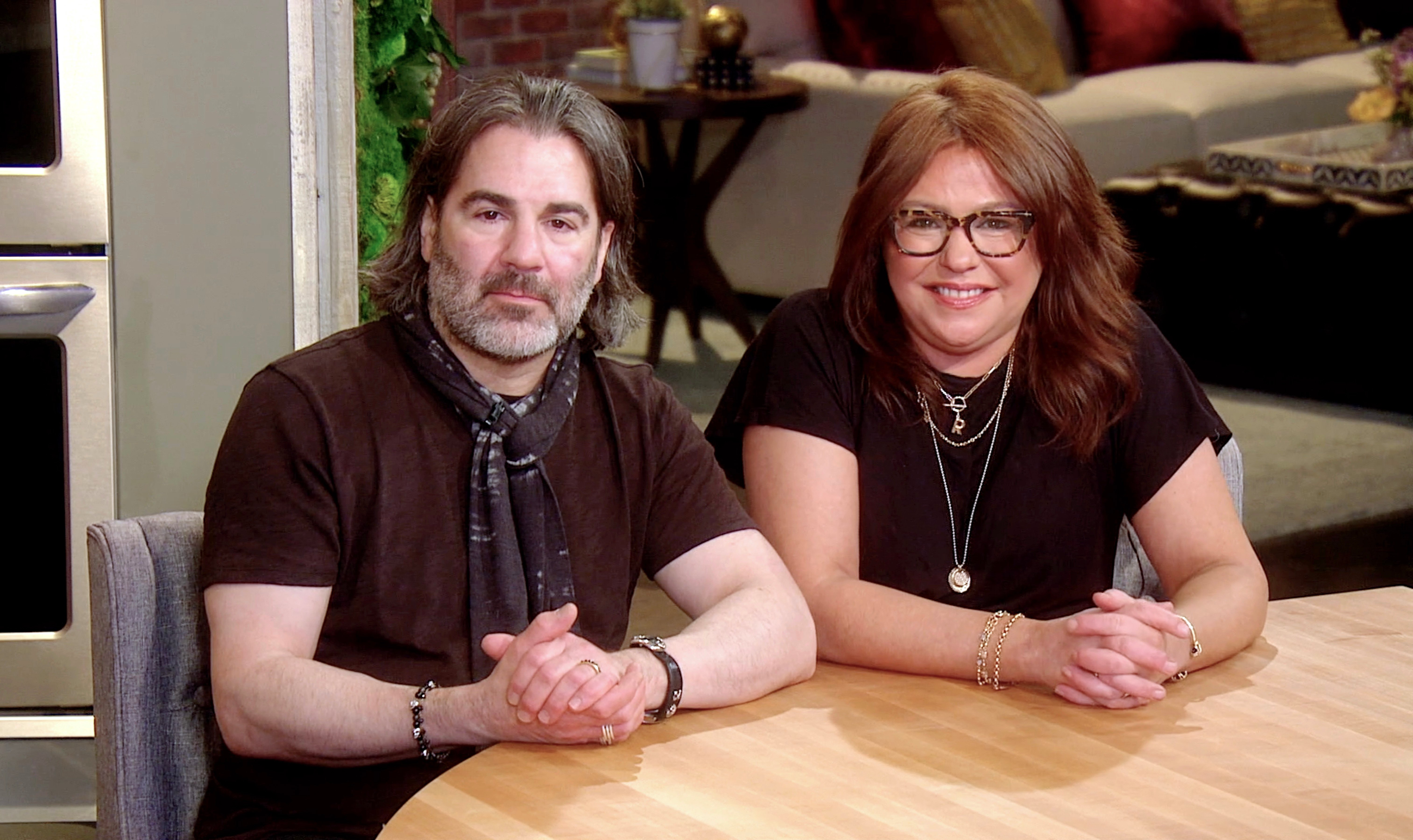 John Cusimano and Rachael Ray sit at a kitchen table and speak during the City of Hope's East End Chapter/Jeanne Kaye League Of New York City's Spirit Of Life Awards