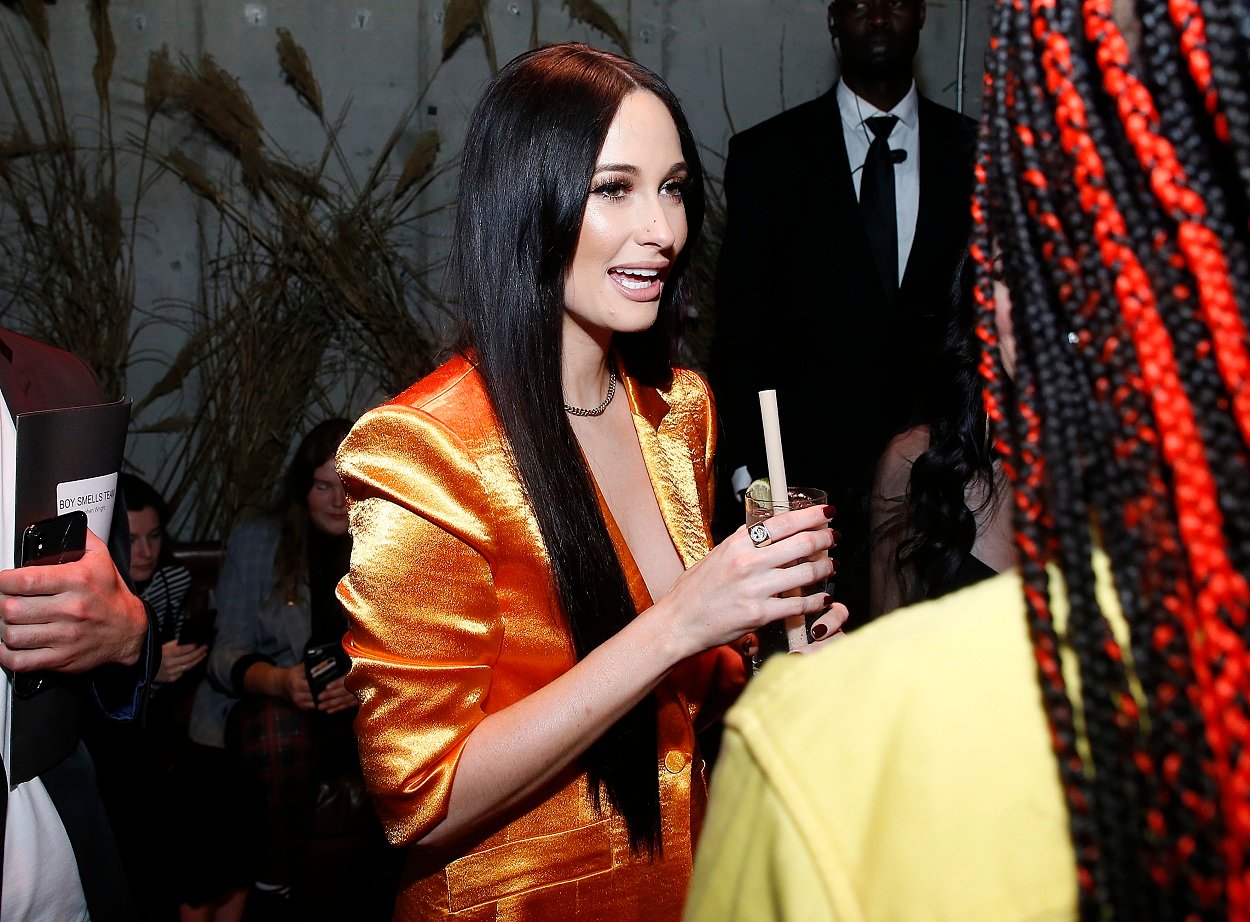 Kacey Musgraves donns an orange suit for the launch of her collaboration with Boy Smells