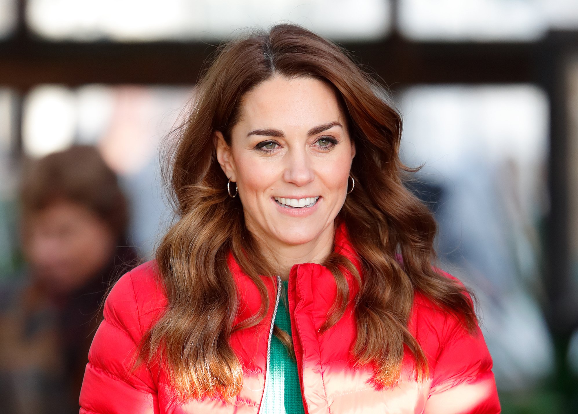 Kate Middleton smiling in a red coat