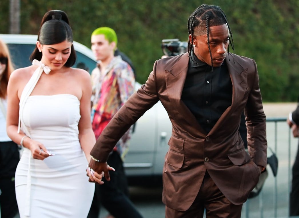 Kylie Jenner in a white dress and Travis Scott in a suit as they arrive together at a premiere in 2019