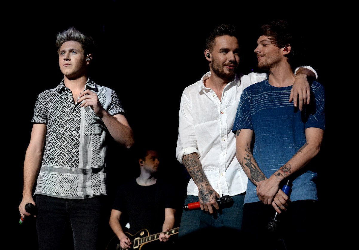 Louis Tomlinson with Liam Payne and Niall Horan from One Direction performing on stage