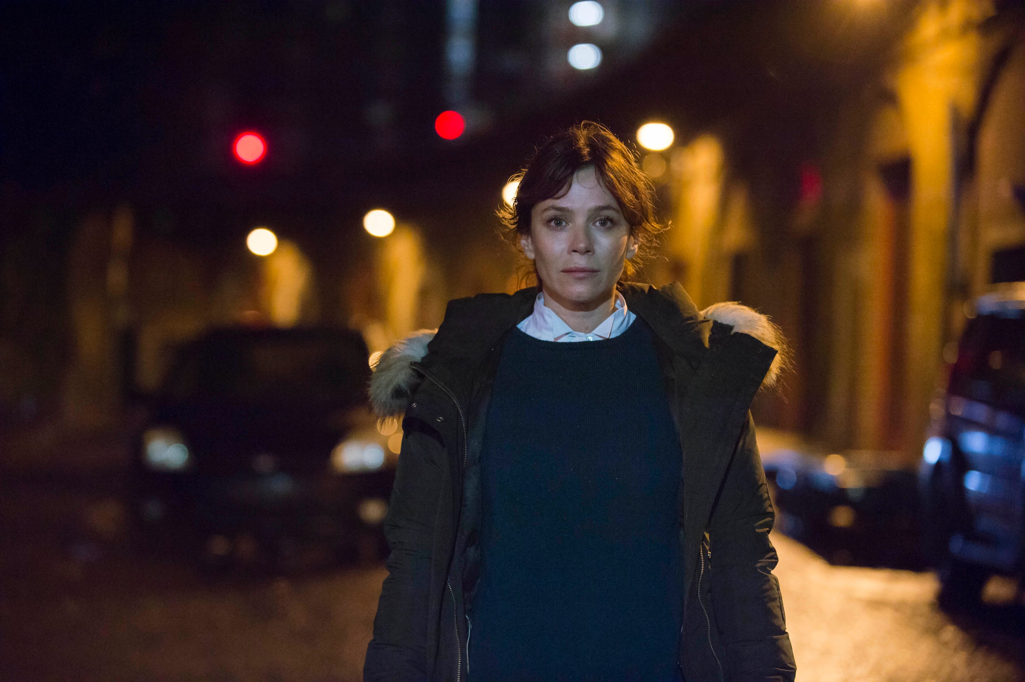 Anna Friel standing on a dark street in Marcella