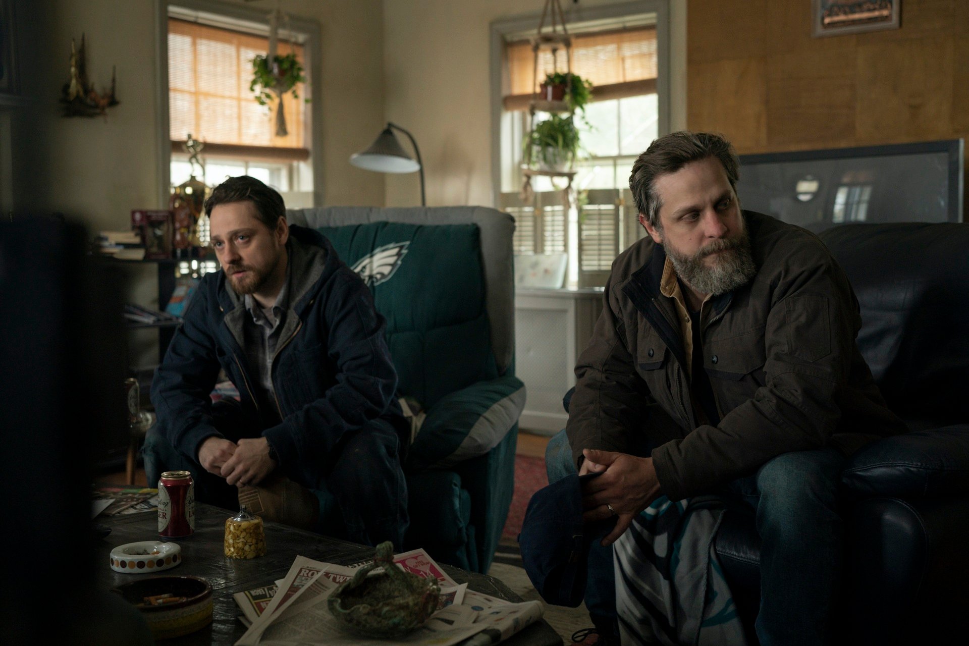 ‘Mare of Easttown’: Robbie Tann as Billy Ross and Joe Tippett as John Ross sit while talking to Mare.