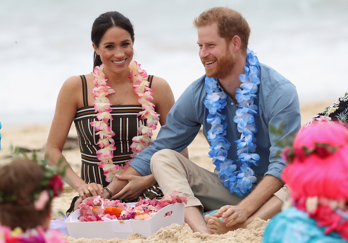 Prince Harry, Duke of Sussex and Meghan, Duchess of Sussex sitting and smiling