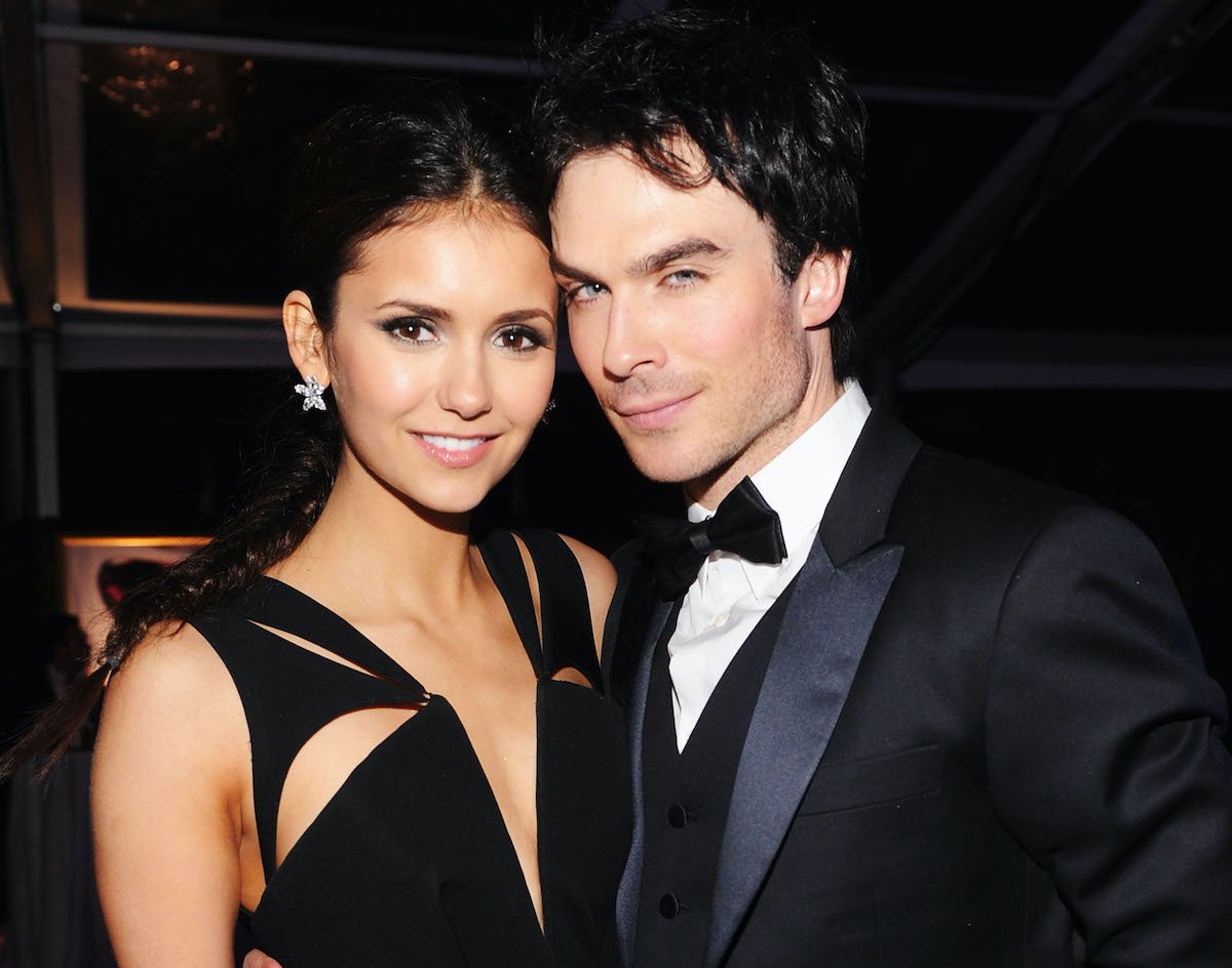Nina Dobrev smiles in a black gown and Ian Somerhalder smirks in a black tux.