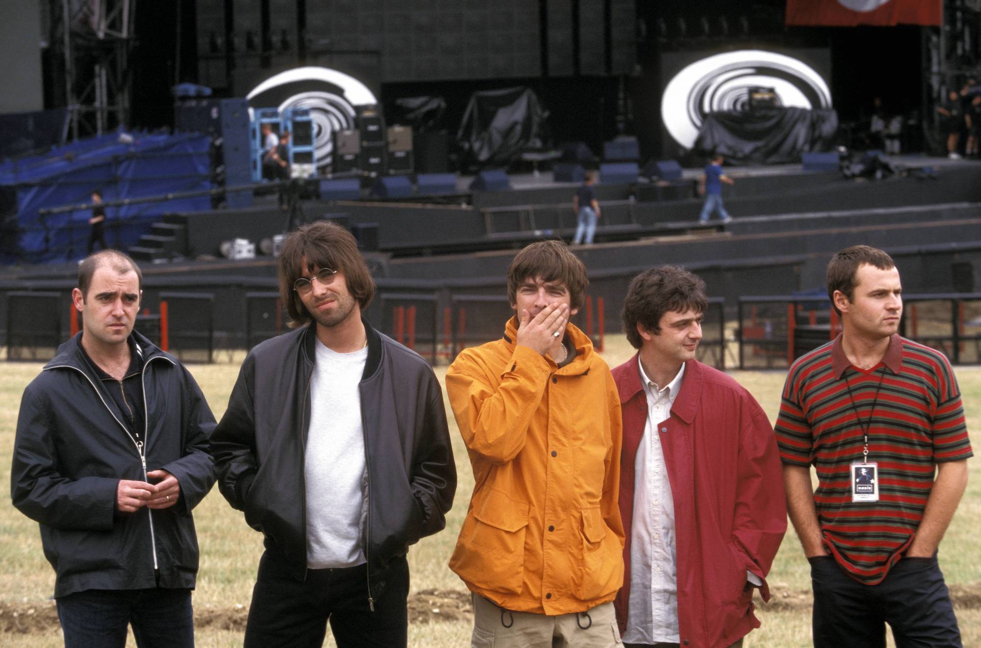 Oasis standing in front of an outdoor stage