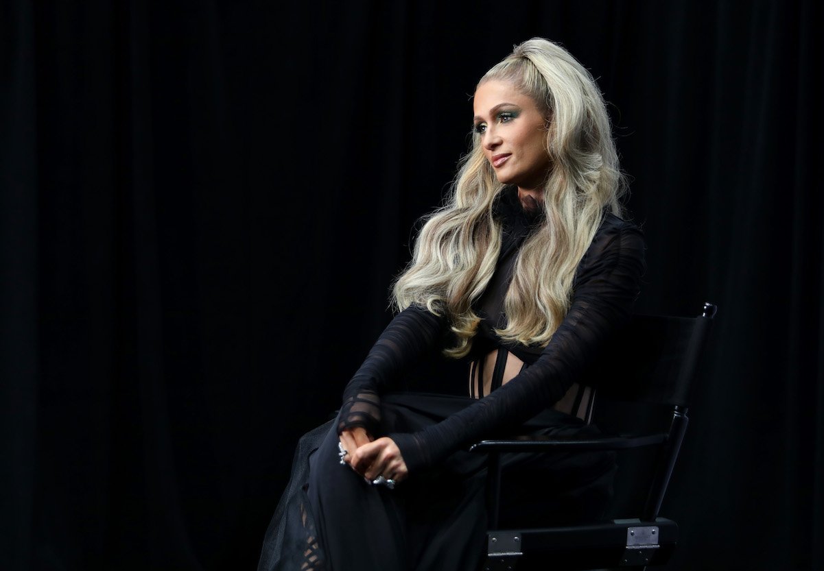 Paris Hilton in a long-sleeve black dress and half-ponytail