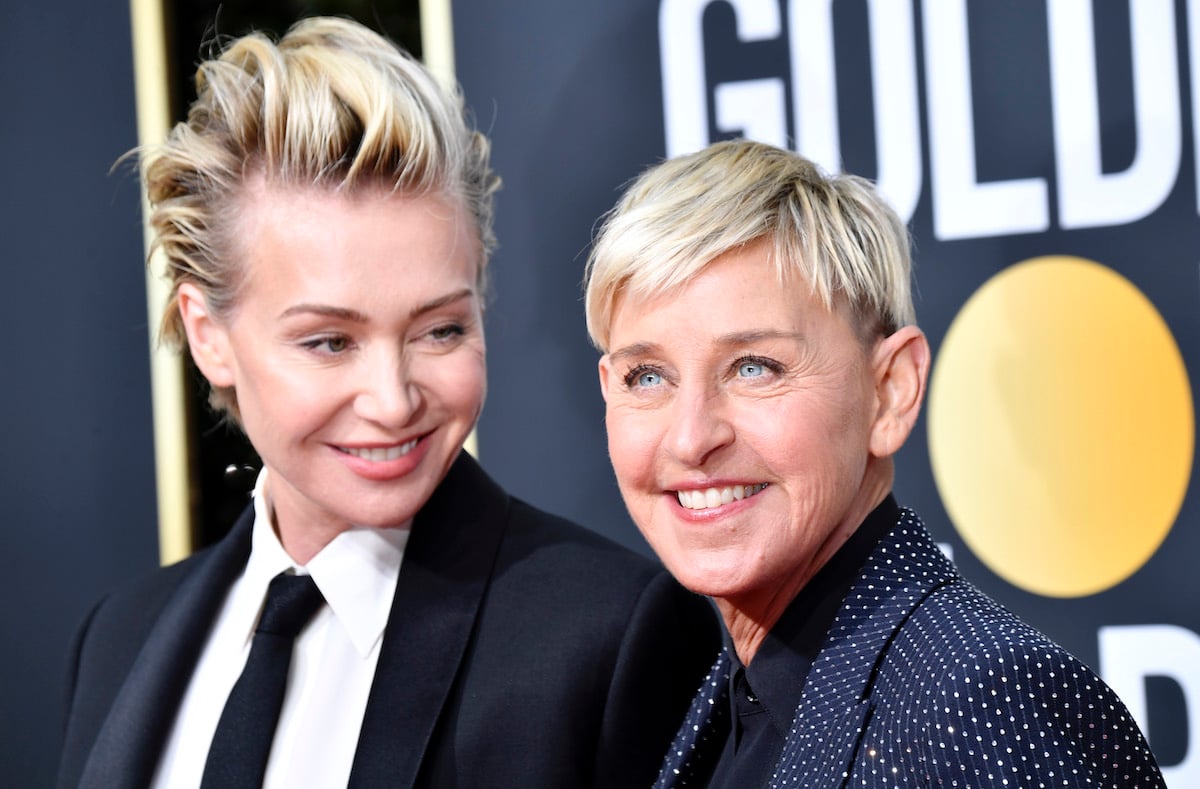 Ellen DeGeneres and Portia de Rossi pose together in suits on the red carpet of the Golden Globes