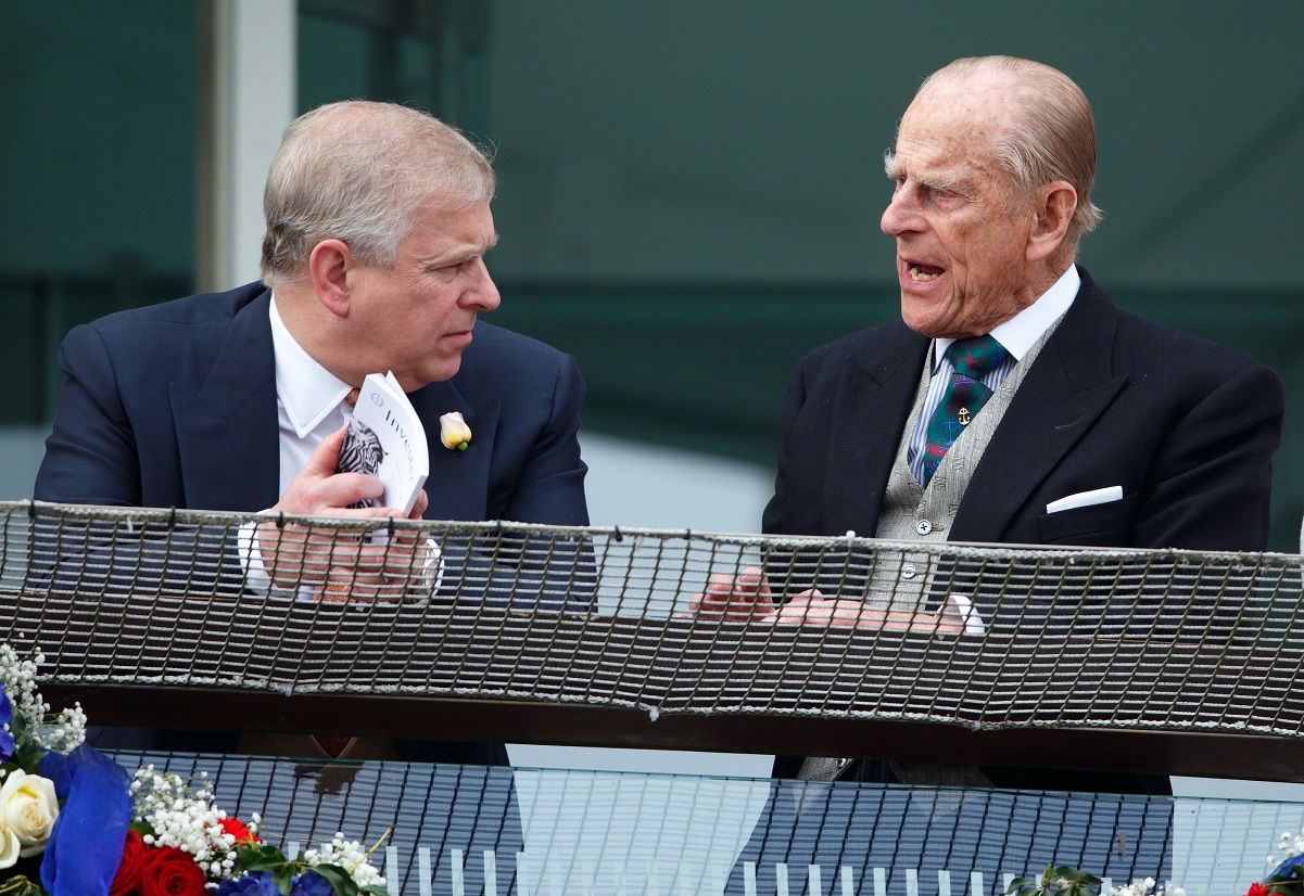 Prince Philip speaking to his son, Prince Andrew, on the balcony of the Royal Box during Derby Day