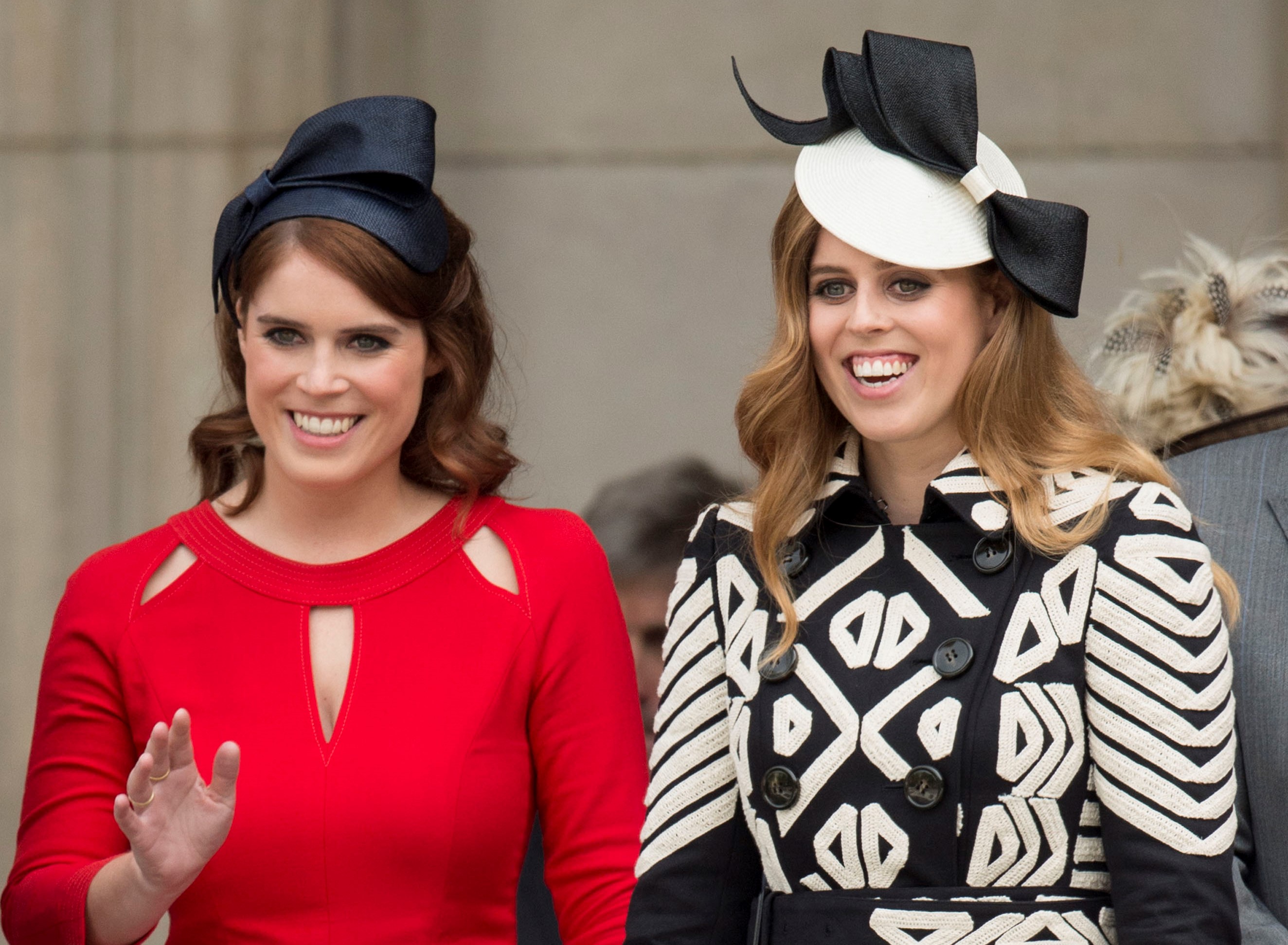 Princess Beatrice in a black and white dress and fascinator, and Princess Eugenie in red at a National Service of Thanksgiving