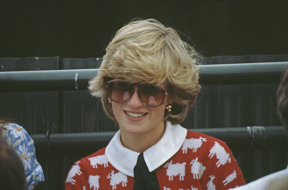 Princess Diana wearing sunglasses and a red sweater