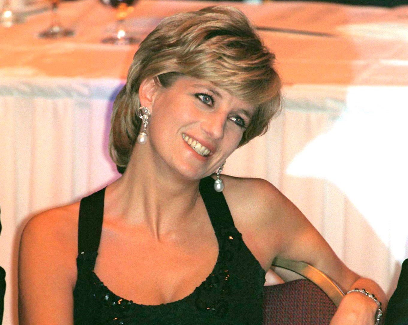 Princess Diana wearing par earrings and a black dress at event to receive an award as Humanitarian of the Year in 1996
