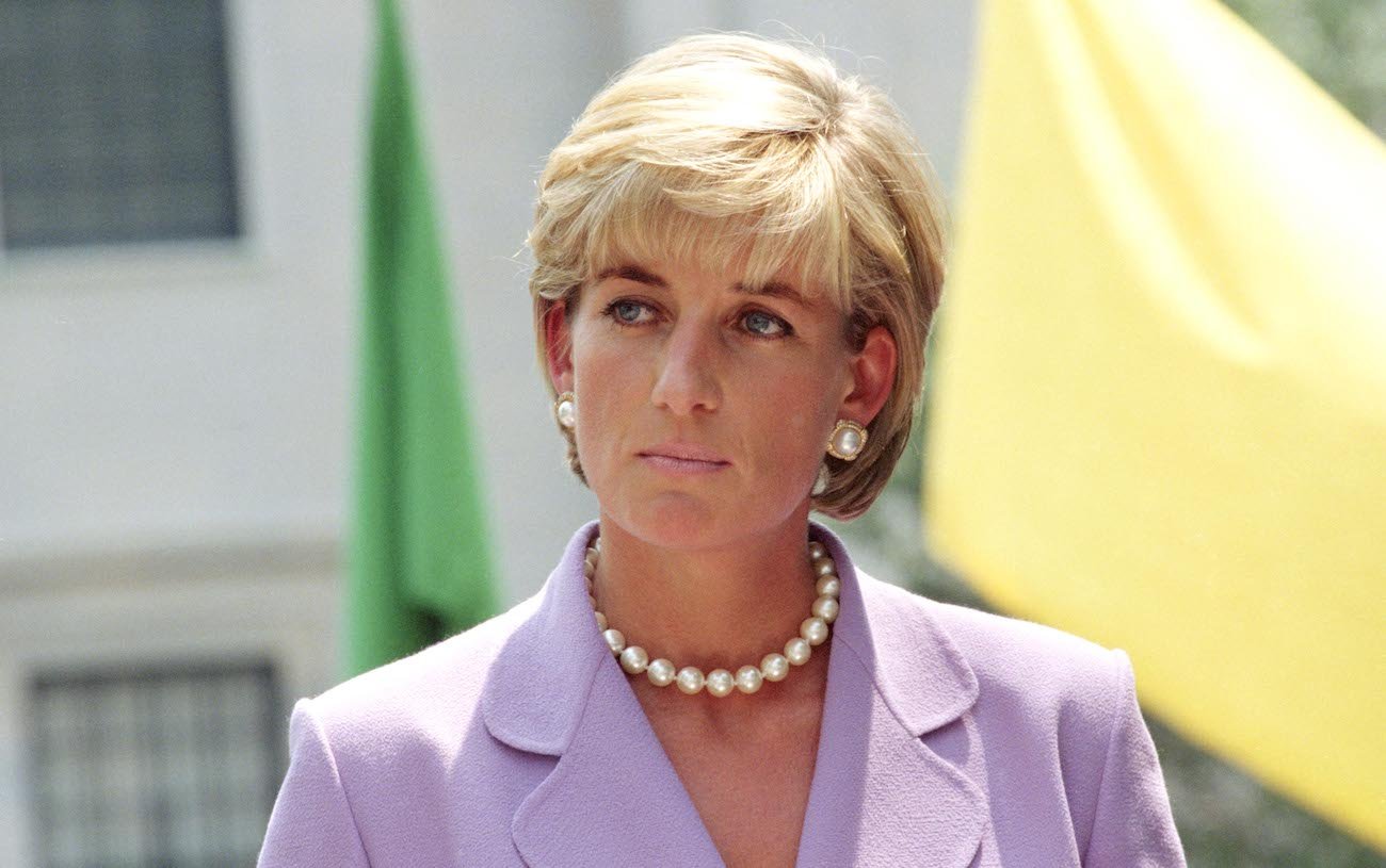 Princess Diana looking on in a purple blazer