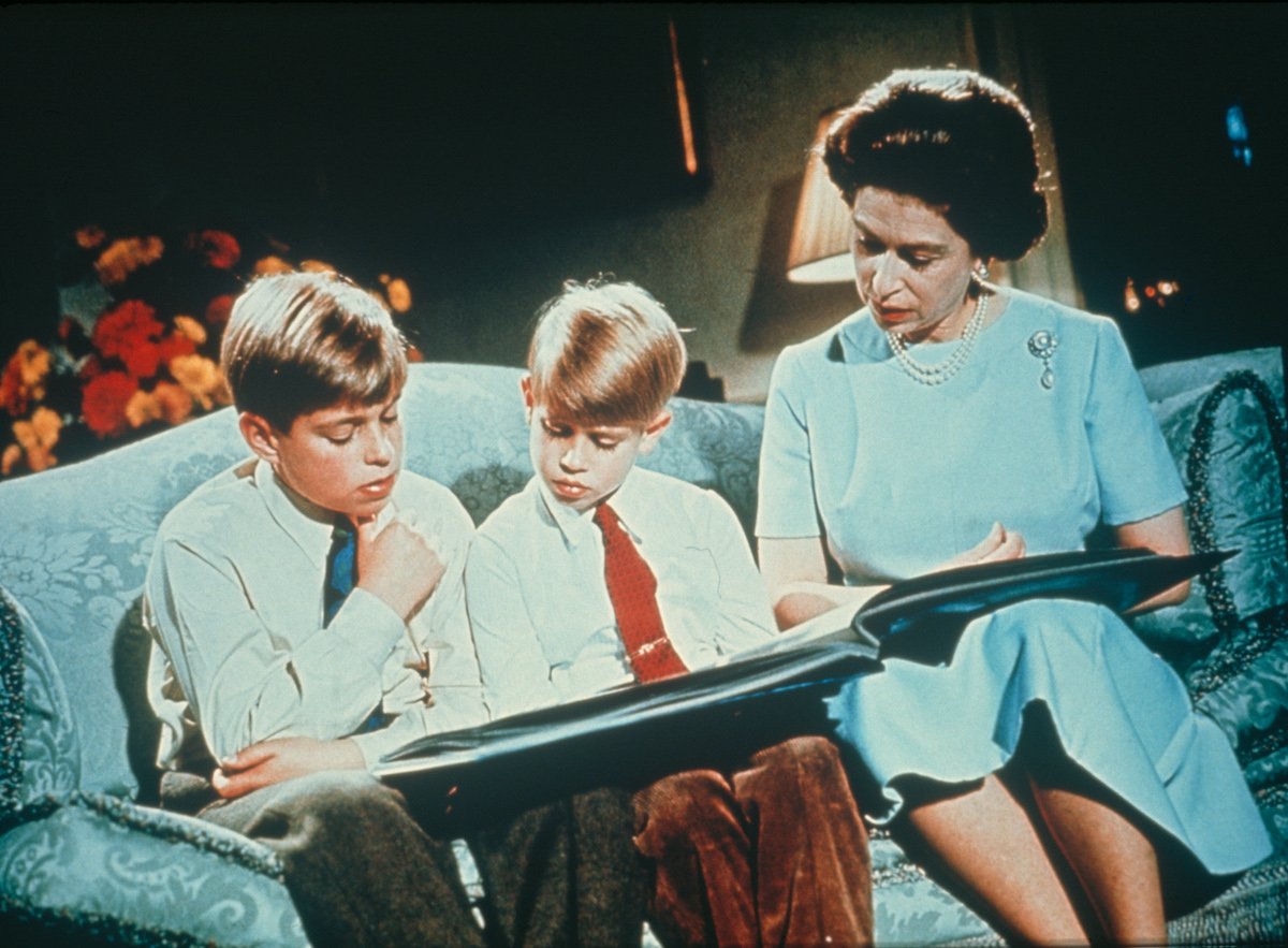 Queen Elizabeth looking at a photo album with Prince Andrew and Prince Edward