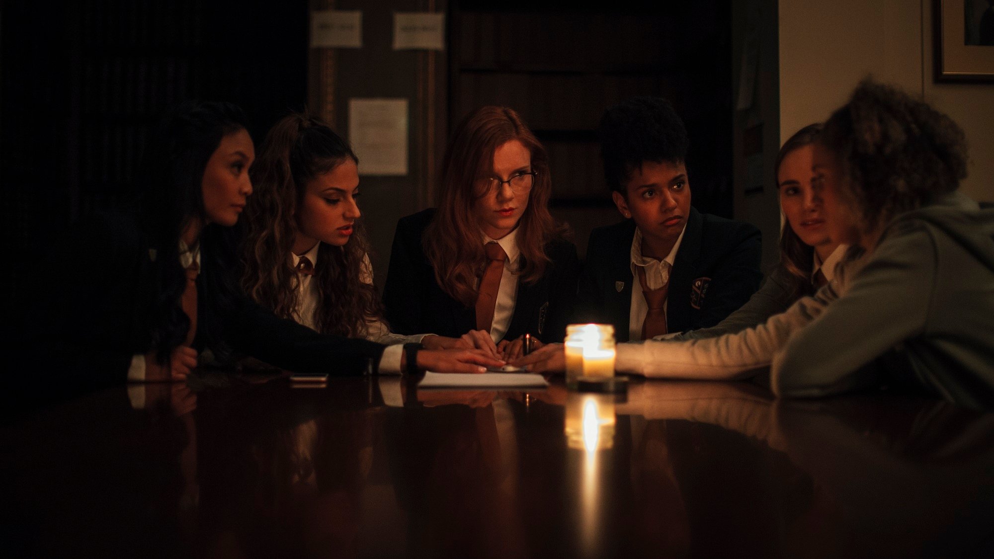 Seance cast plays with a Ouija board