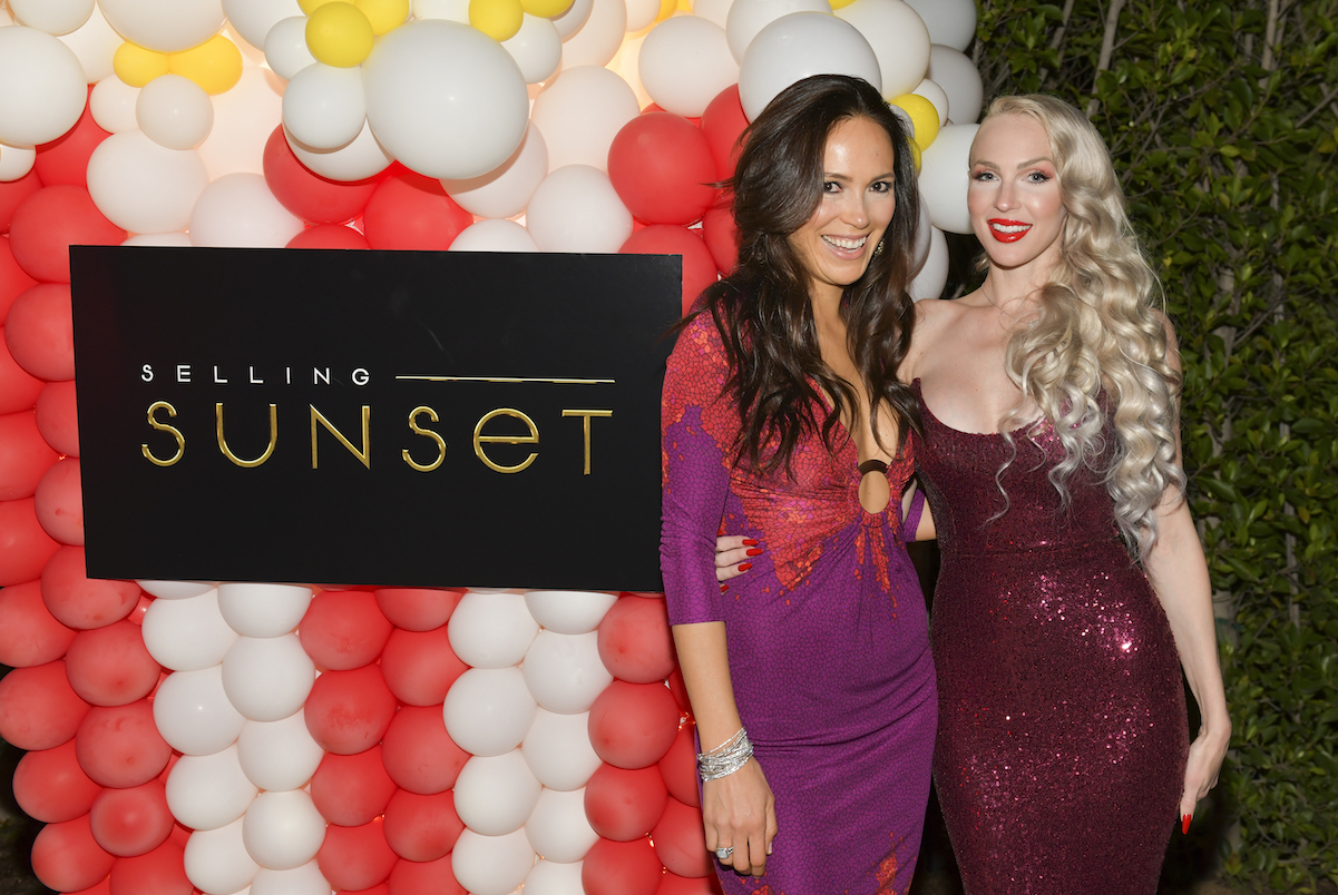 Davina Potratz and Christine Quinn pose in front of a 'Selling Sunset' sign in 2019