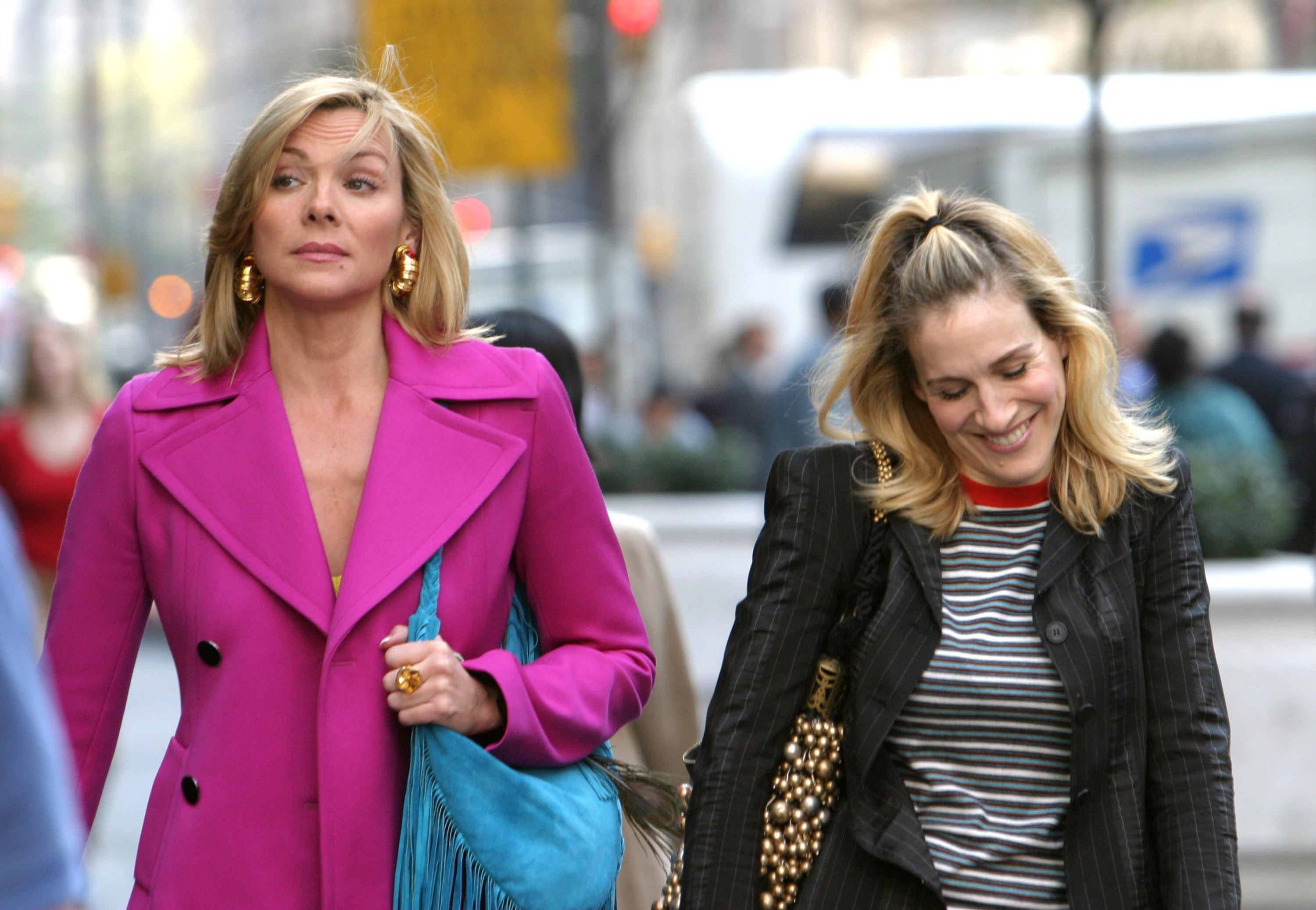 Kim Cattrall as Samantha Jones and Sarah Jessica Parker as Carrie Bradshaw walk down a Manhattan street while filming an episode of 'Sex and the City'