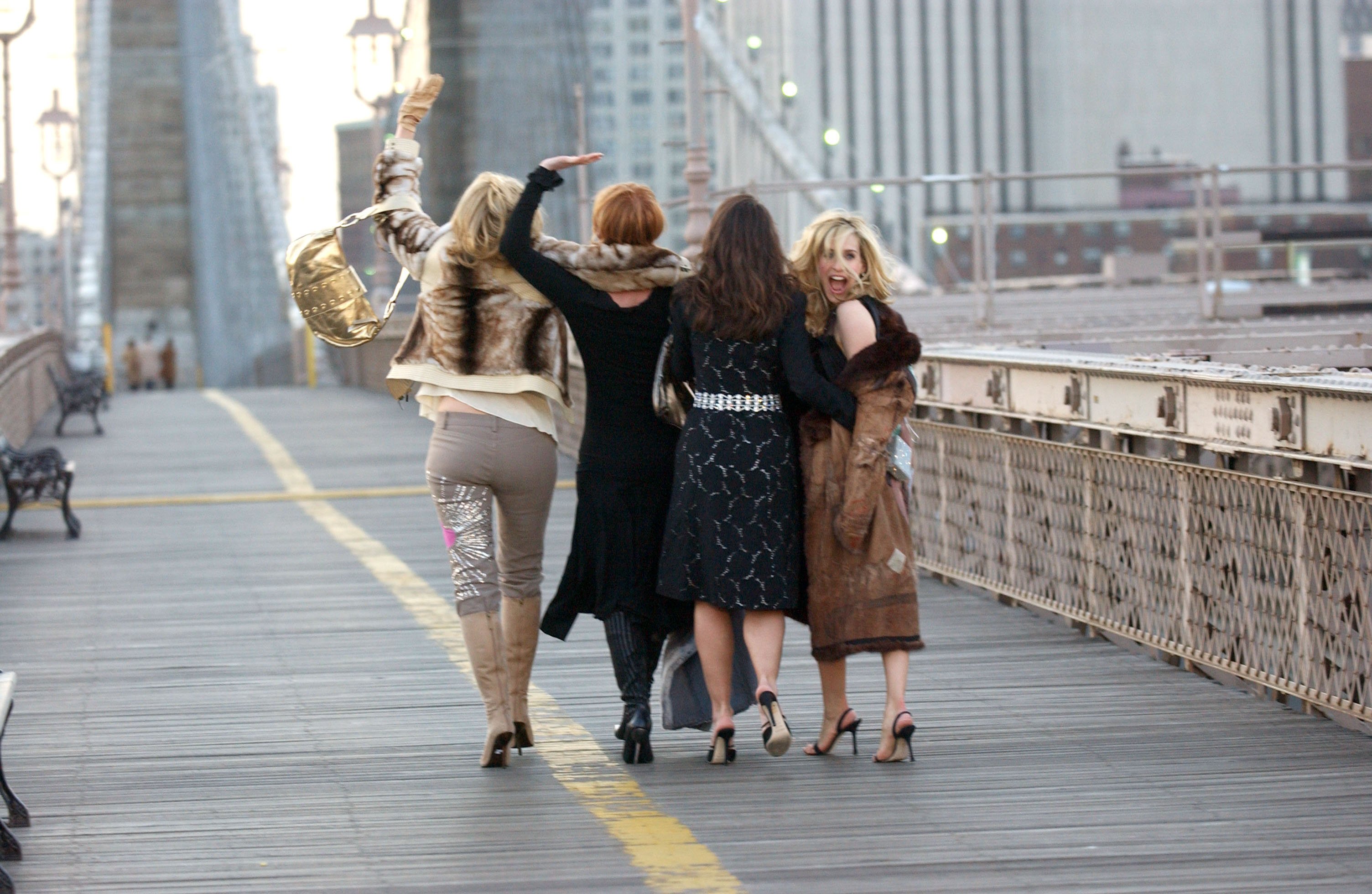 Kim Cattrall, Cynthia Nixon, Kristin Davis and Sarah Jessica Parker are photographed from behind walking across the Brooklyn Bridge during a promotional shoot for 'Sex and the City: The Movie'