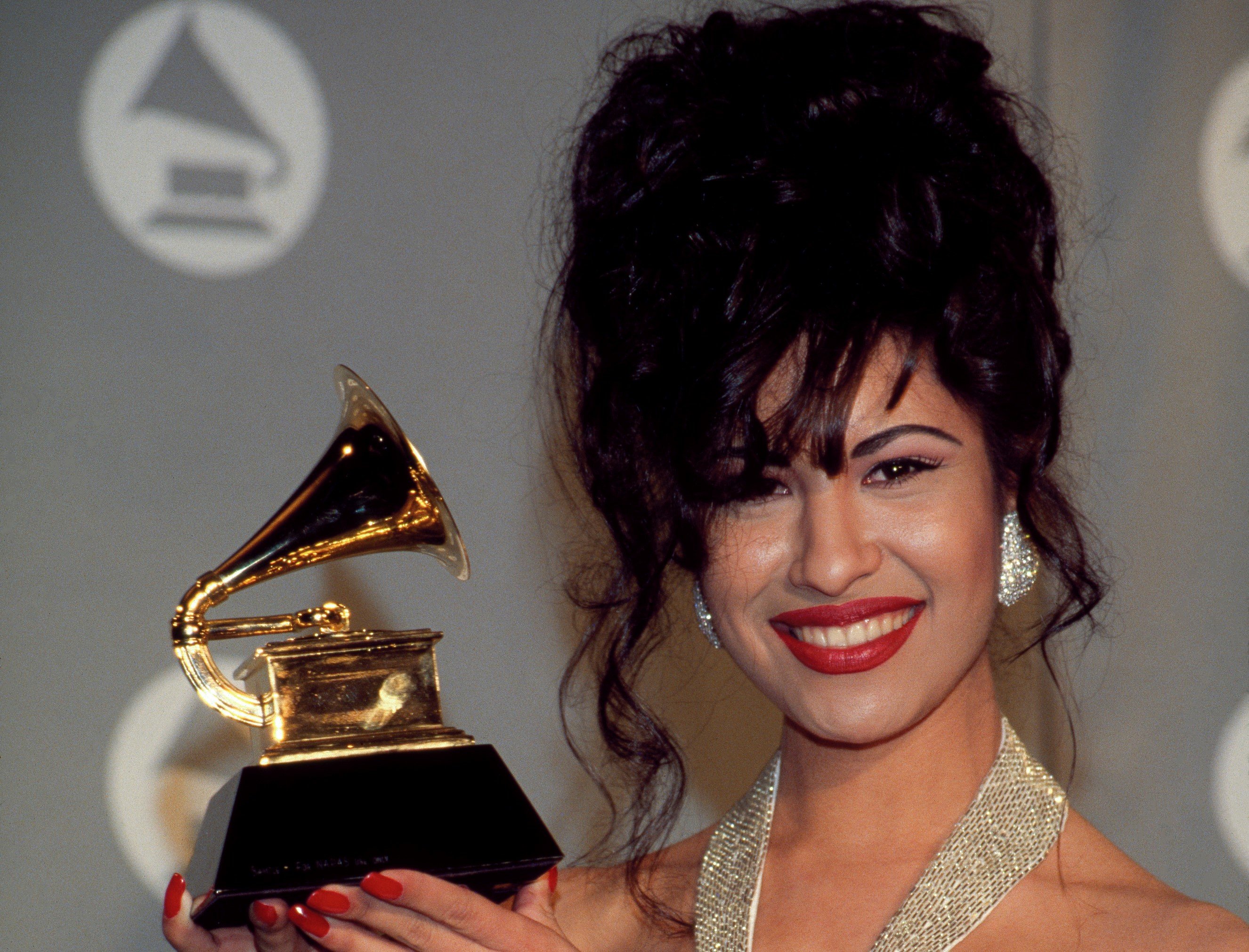Singer Selena Quintanilla holding the Grammy Award she won in 1994