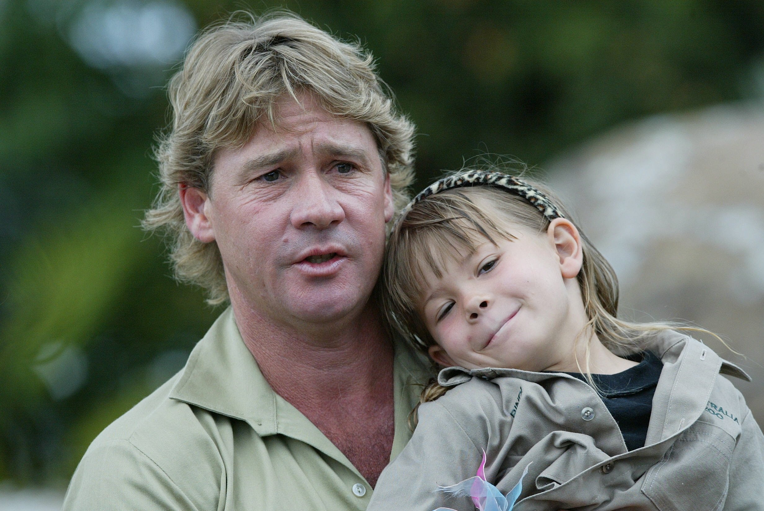 Steve Irwin at a press conference, holding Bindi Irwin.