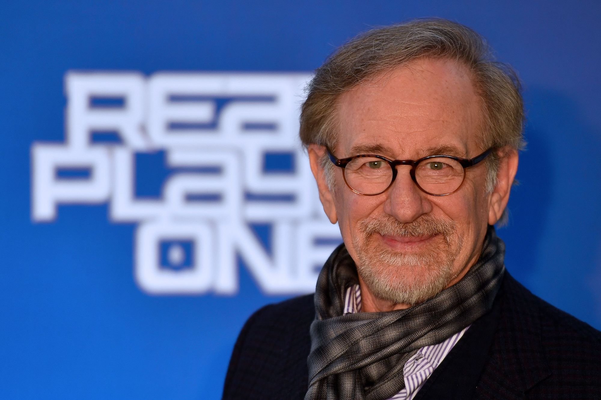 Steven Spielberg smiling in front of a blue background
